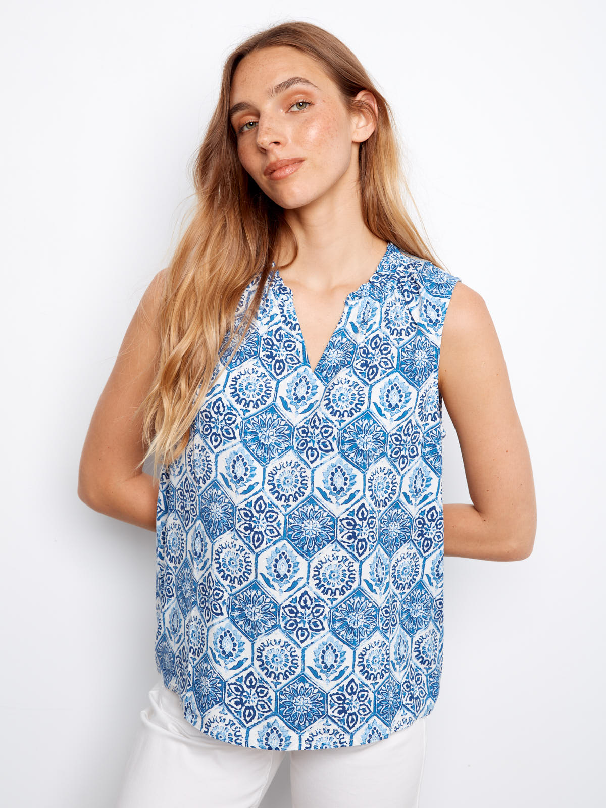 Model in a blue patterned sleeveless Charlie B Layered or Not Ruffle Top, styled with white pants by Charlie B.