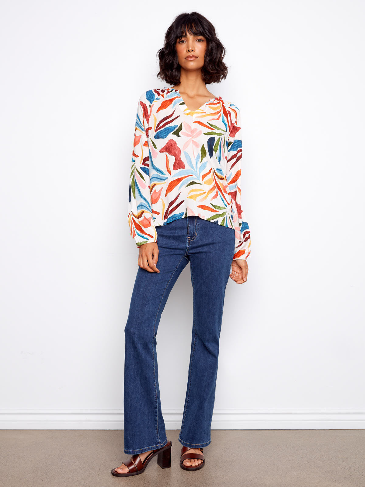 Charlie B Solstice V-Neck Raglan Top with colorful leaf pattern, paired with blue jeans for a casual look by Charlie B.