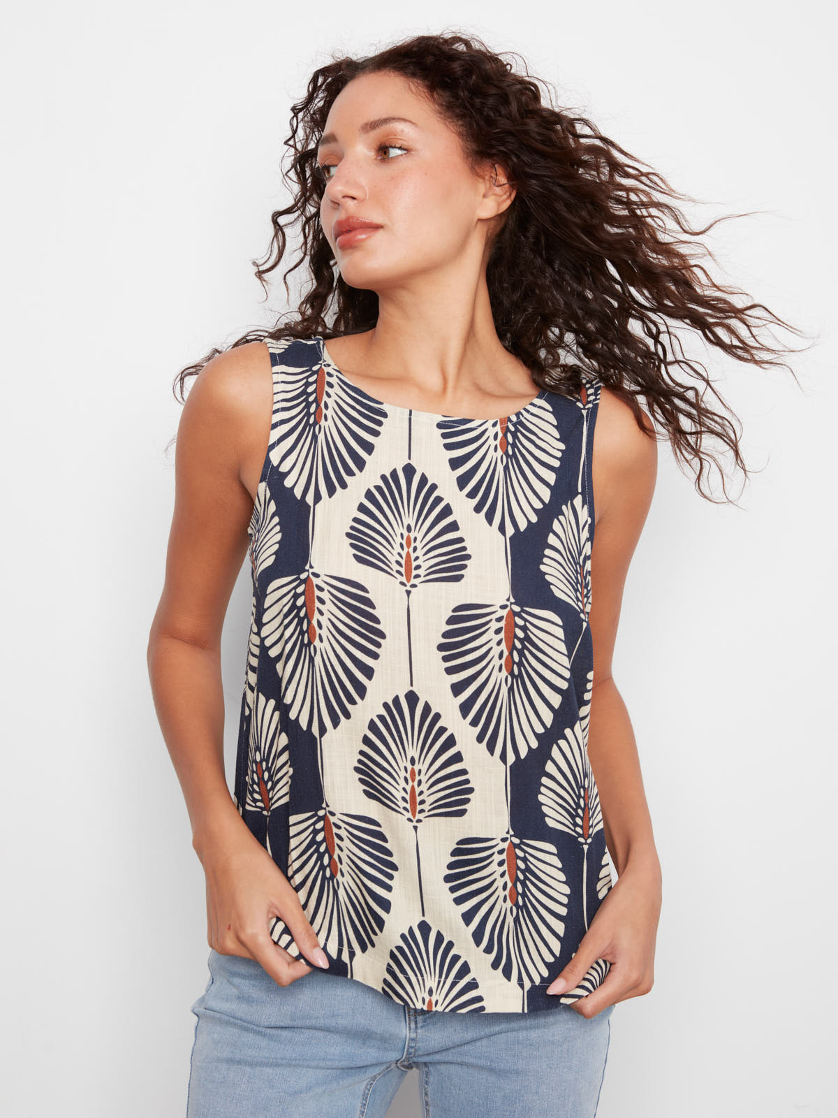 Charlie B Tahiti Linen Sleeveless Top in navy and cream with bold leaf print, styled with light denim jeans.