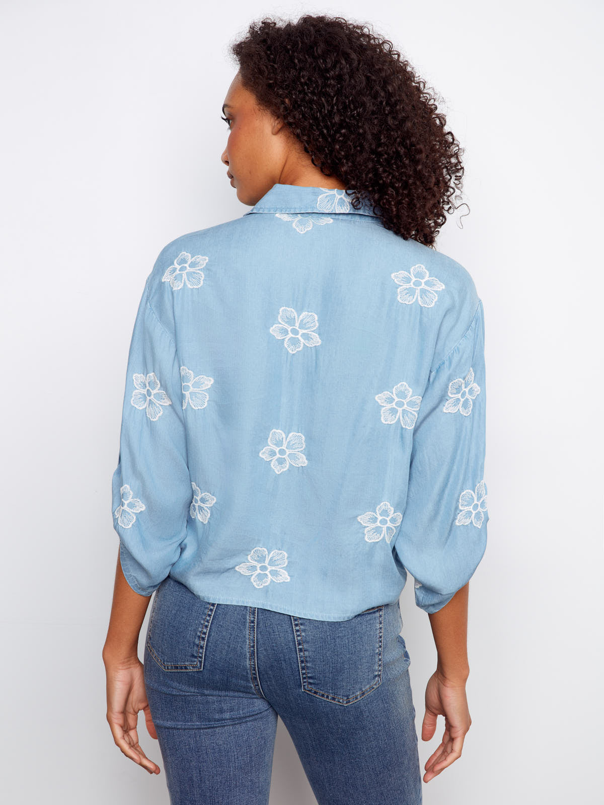 Back view of Charlie B Embroidered Flower Tencel Button Front Tie Top in light blue with white floral embroidery by Charlie B