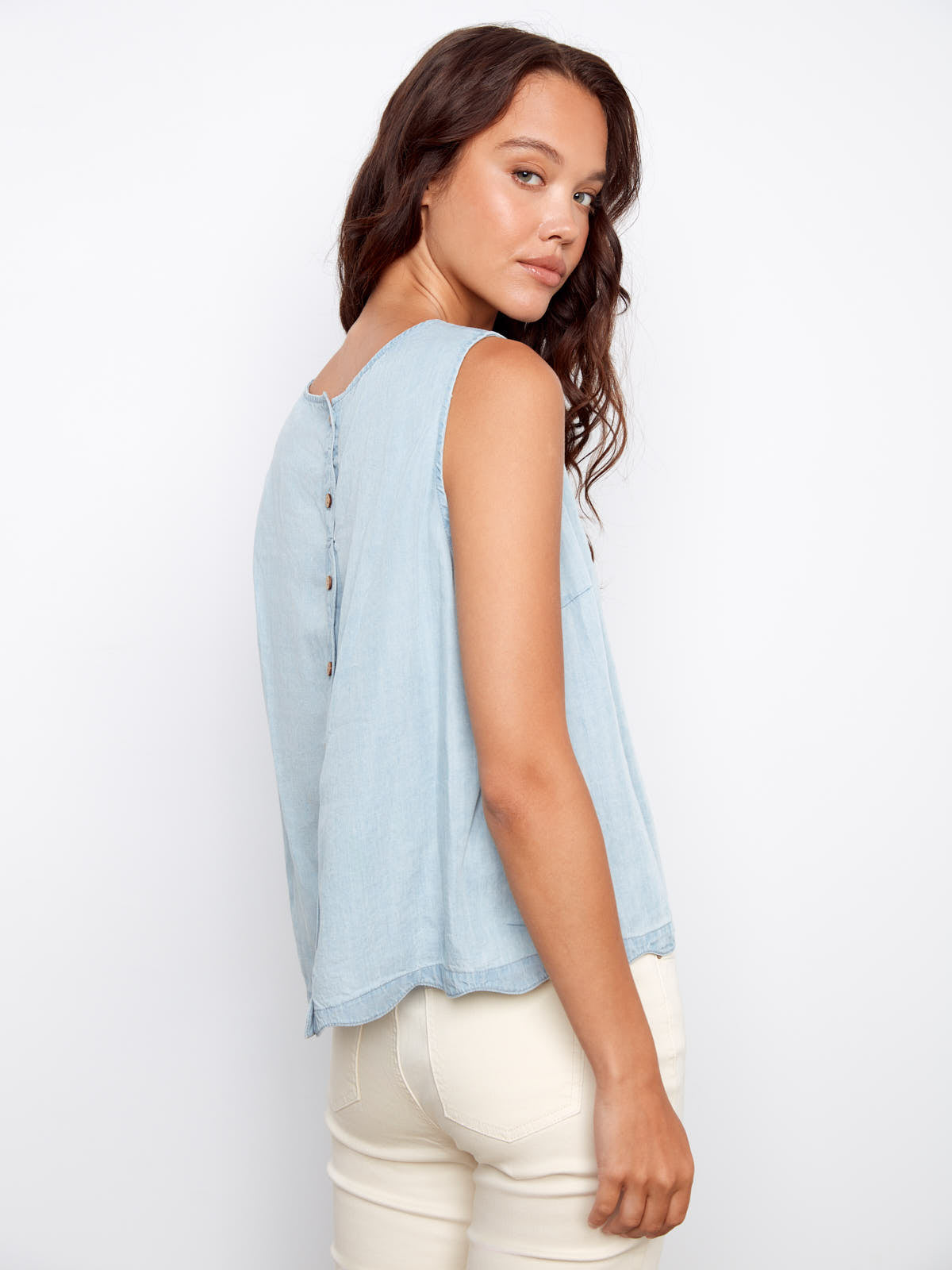 Light blue Charlie B Scallop Tencel Top with button back detail paired with cream pants in a casual style.