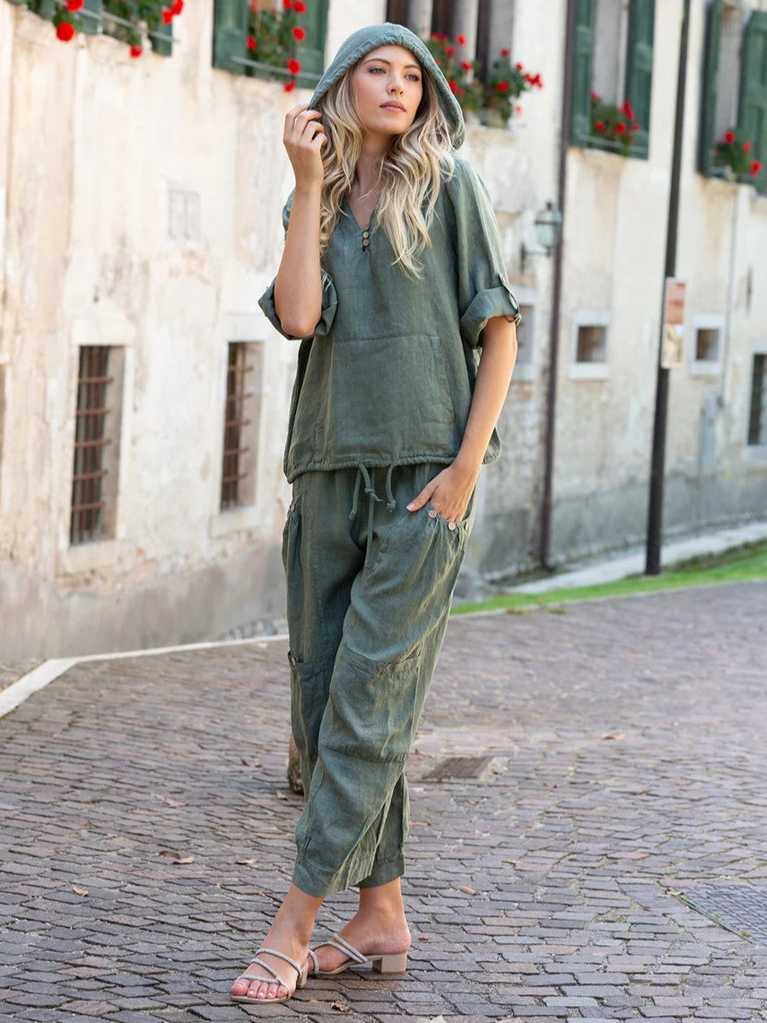 Olive green Beachy Linen Popover Hoodie by Cherishh styled with relaxed linen pants on cobblestone street.