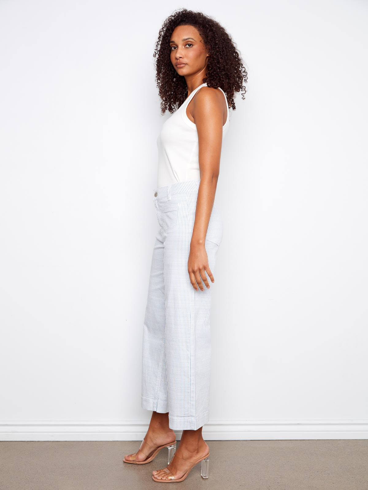 Model in white top paired with light blue striped Charlie B Double Trouble Lines Flare Jean by Charlie B denim jeans