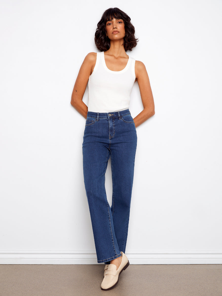Model showcasing Charlie B Charlotte Straight Leg Denim Jeans in indigo with a white tank top and beige loafers by Charlie B.