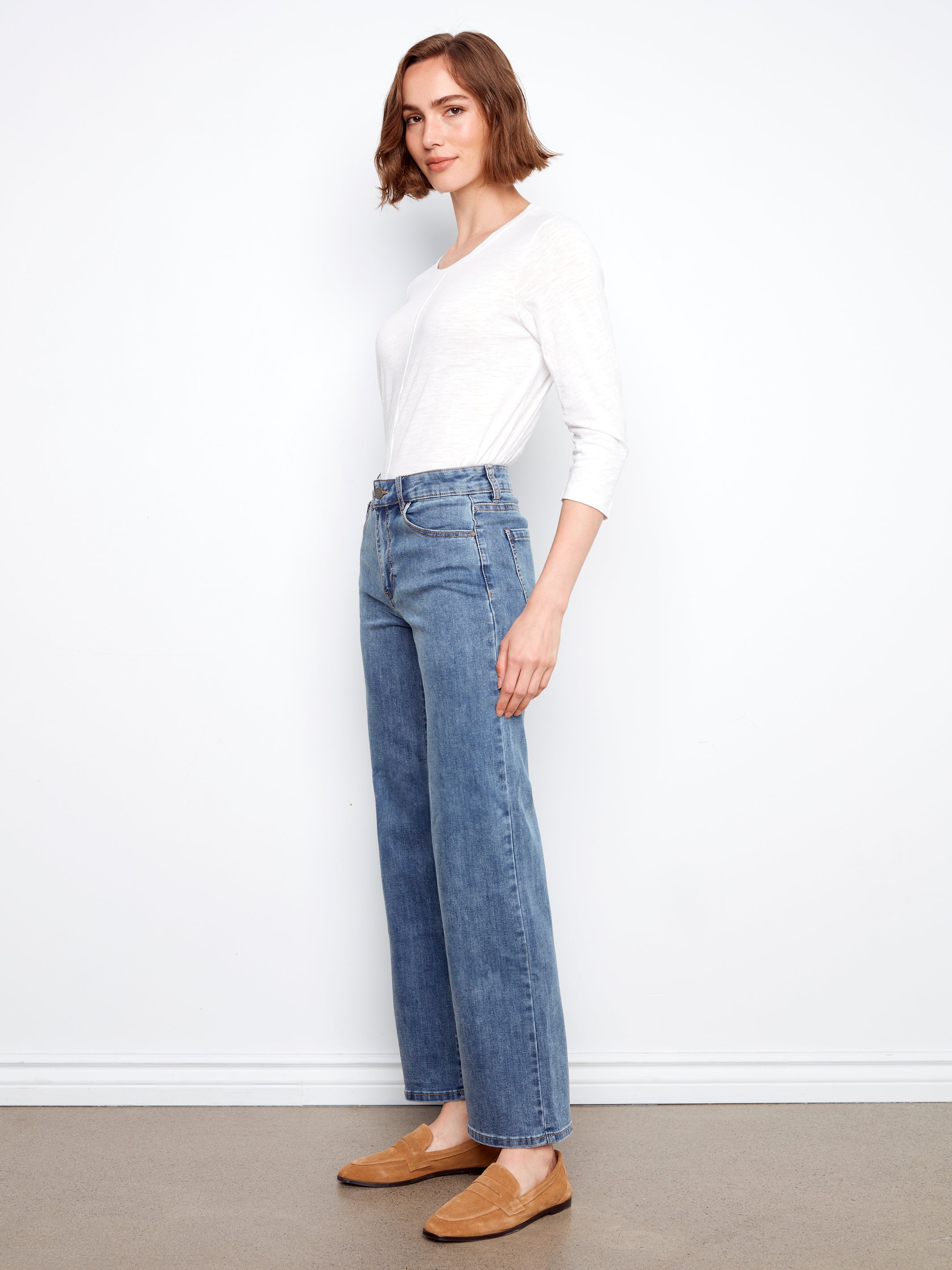 Slim fit white long sleeve top paired with Charlie B Chloe Wide Leg Denim Jeans by Charlie B and tan loafers