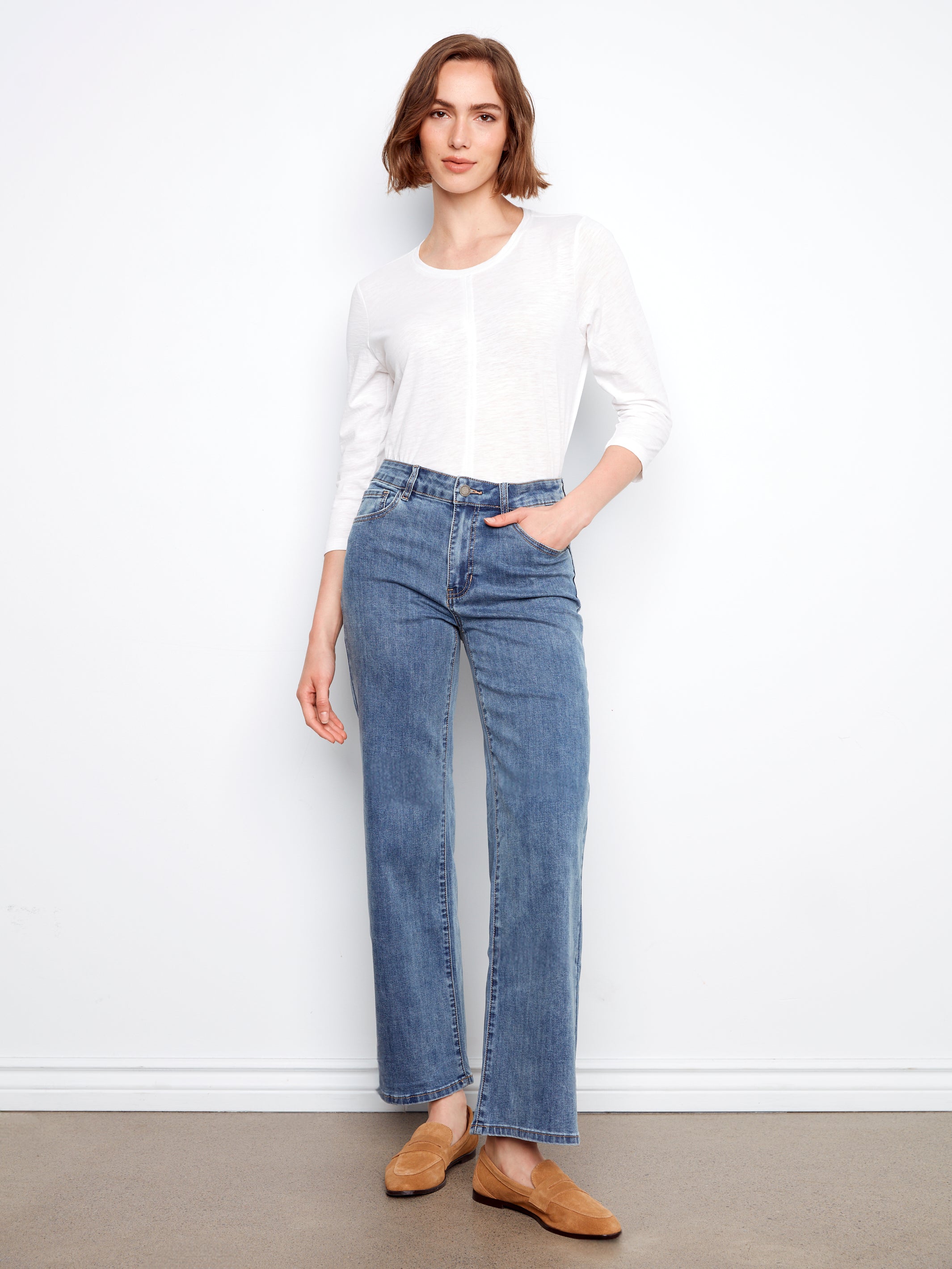 Charlie B Chloe Wide Leg Denim Jeans in medium blue styled with a white long sleeve top and tan shoes by Charlie B