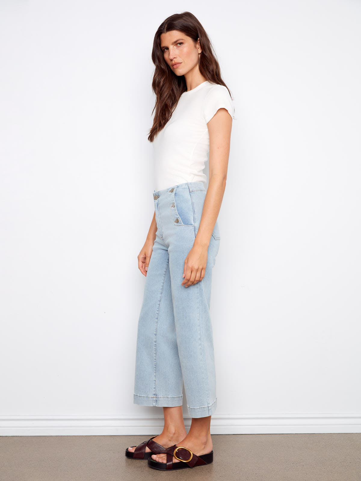 Side view of Charlie B Triple Threat 26” Denim Capris in light wash denim styled with white top and sandals by Charlie B.
