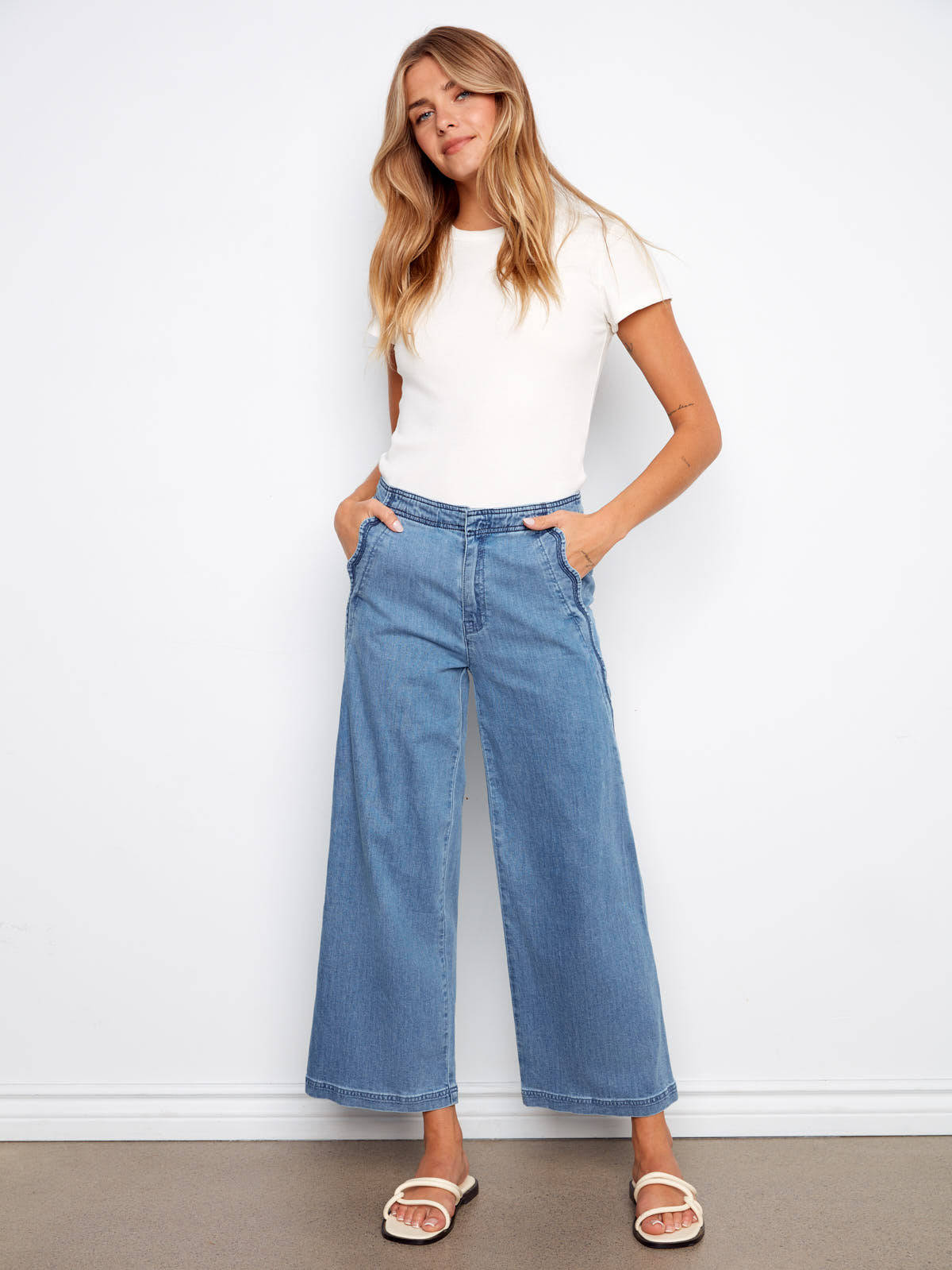 Charlie B Scallop Wave 27” Denim Pant in light blue with wide leg cut styled with a white top by Charlie B.