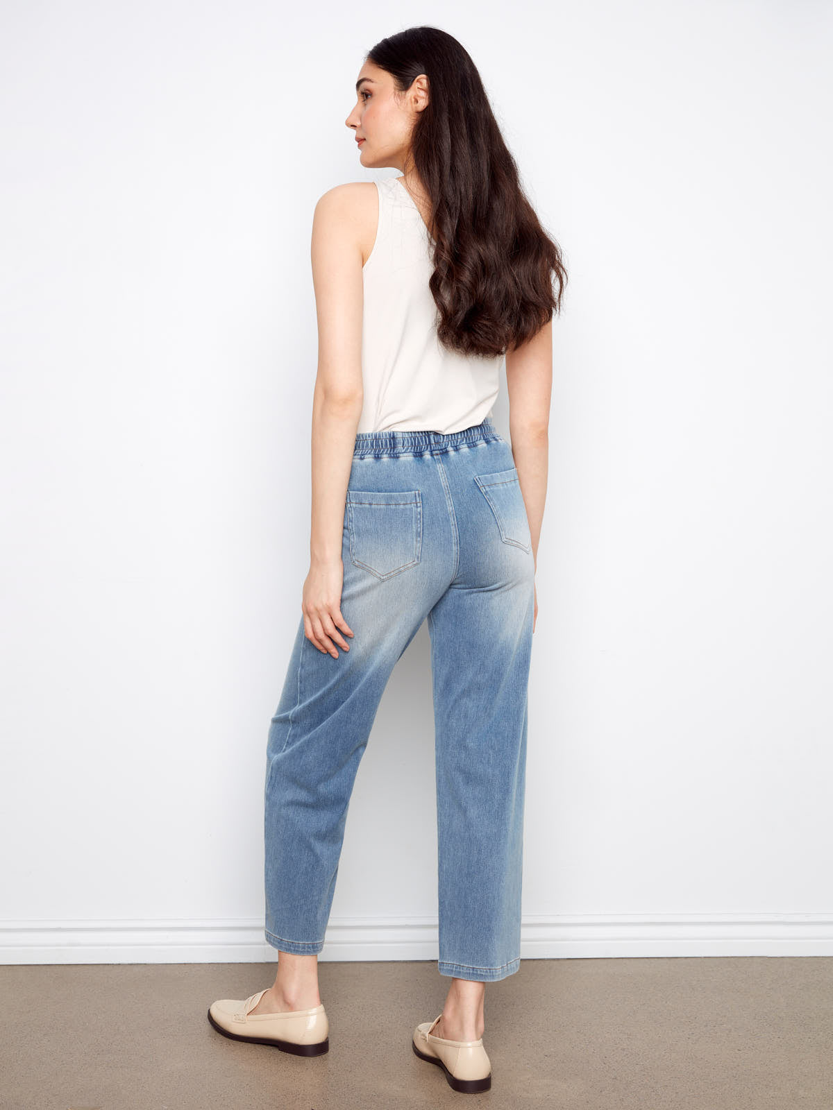 Back view of a model wearing Charlie B Nautical Tie Waist Denim Pant in light blue by Charlie B