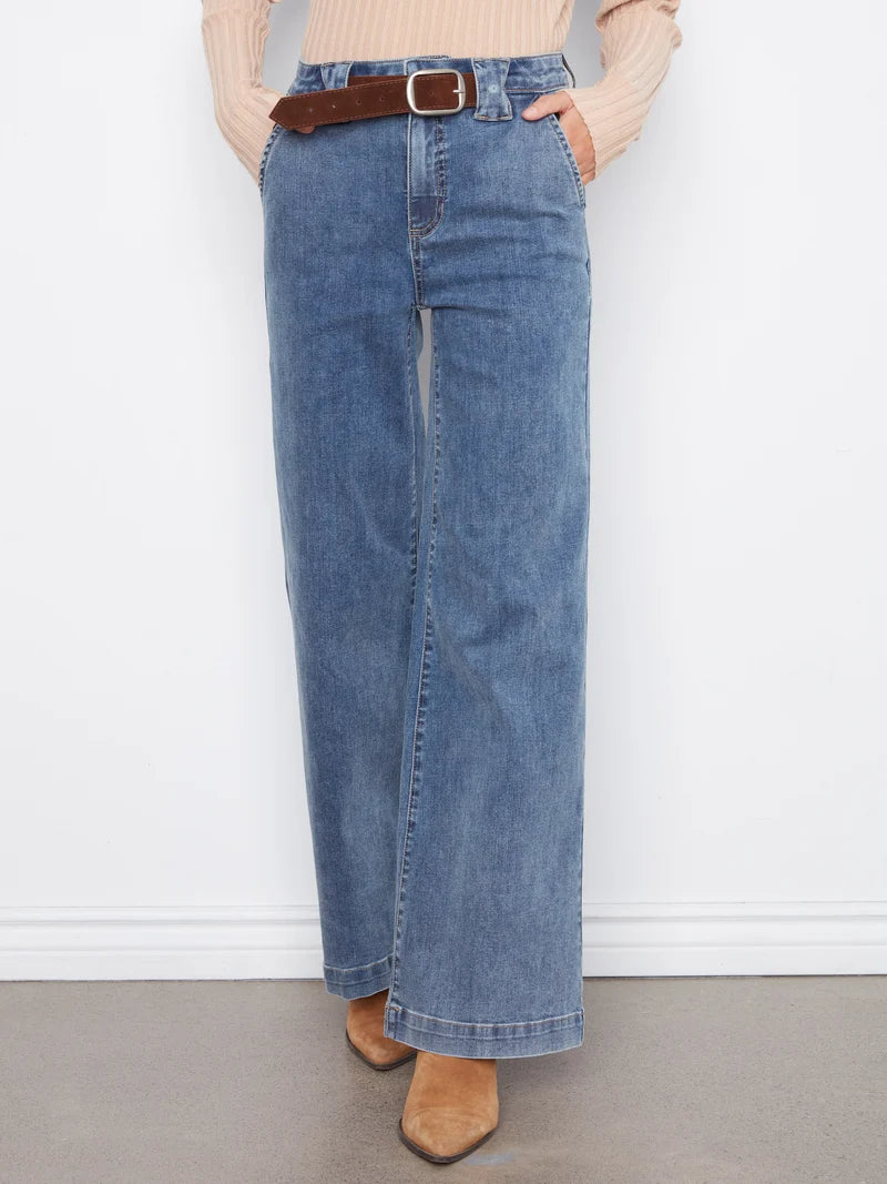 Blue wide-leg jeans with a brown belt, cream ribbed sweater, and tan ankle boots