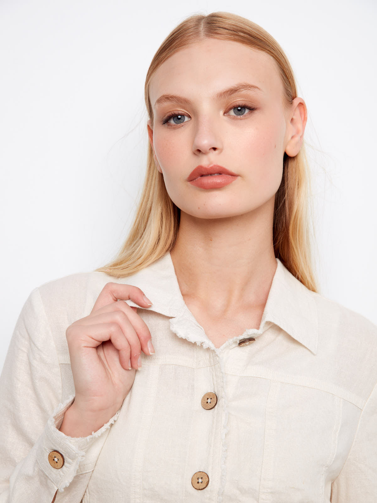 Close-up of a light champagne Charlie B Foiled Linen Jacket with wooden buttons and frayed edges by Charlie B.