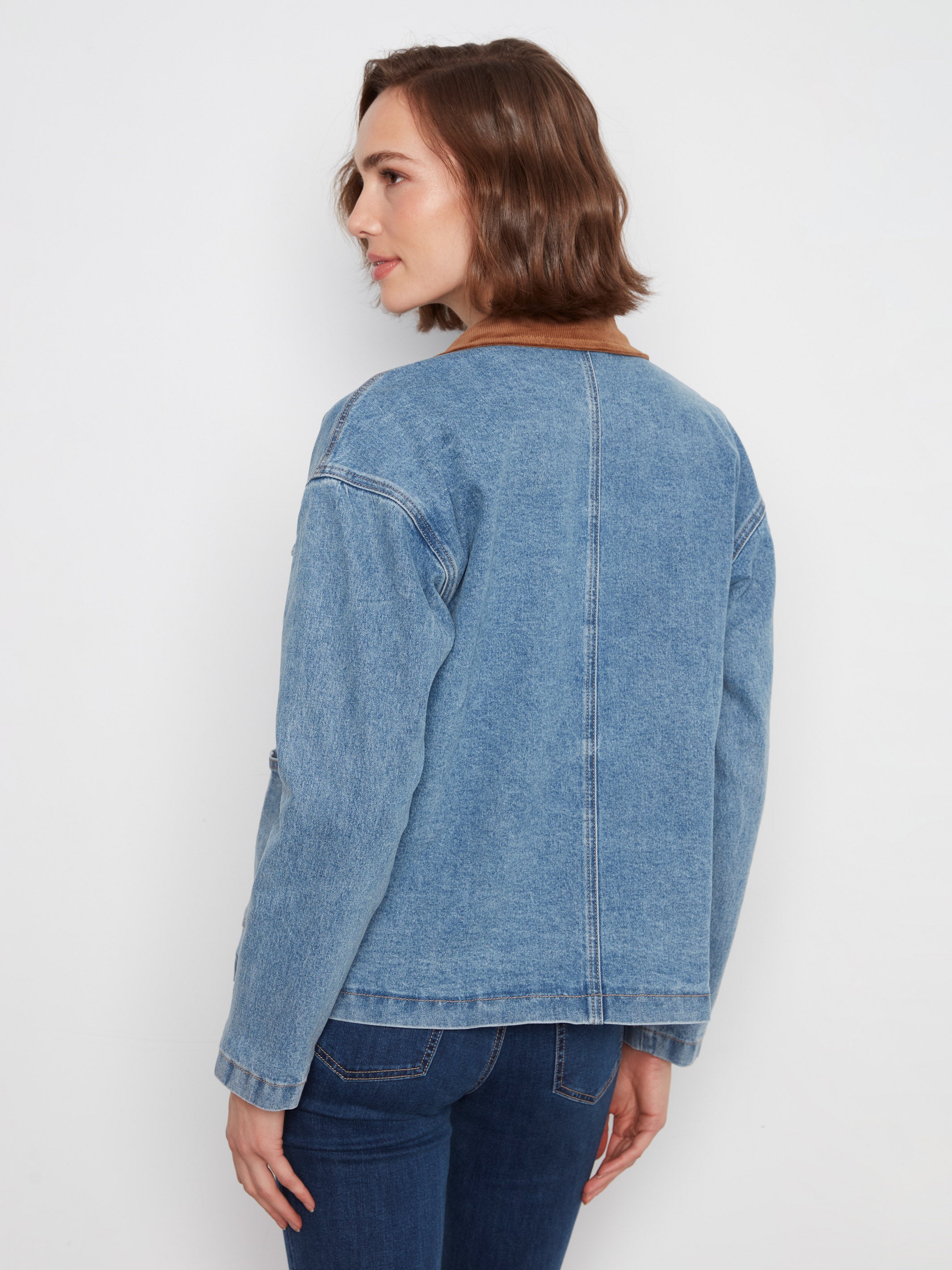 Back view of a light blue denim jacket with a brown collar paired with dark blue denim jeans.