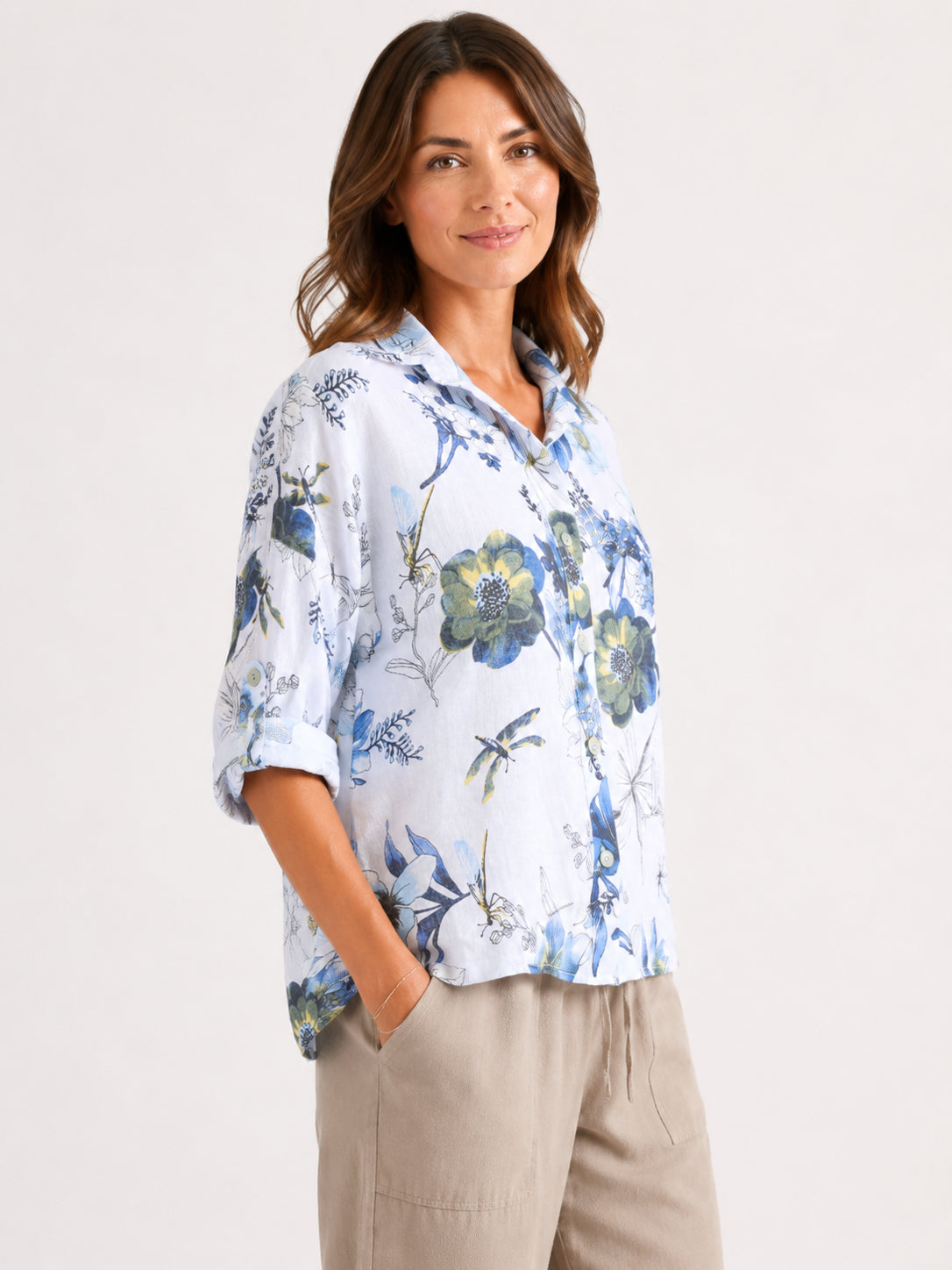 Light blue floral button-up shirt with rolled sleeves paired with beige pants against a plain background.