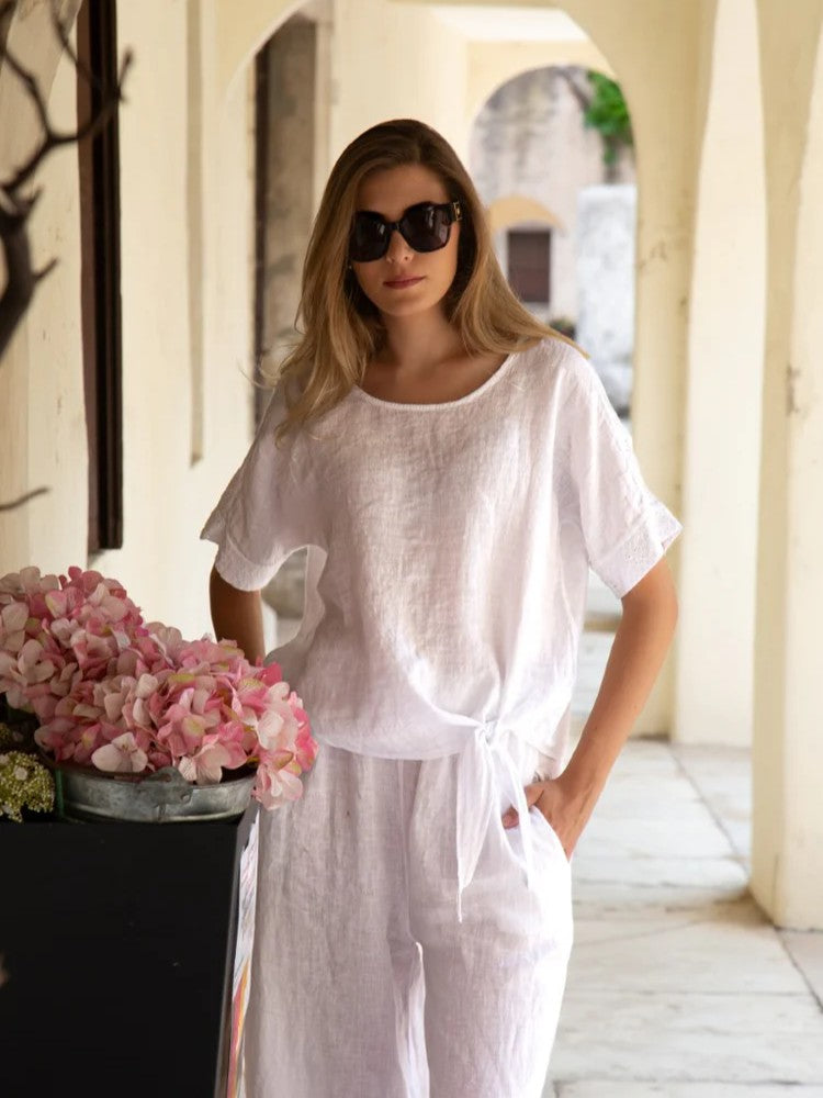 Eyelet Ladder Linen 3/4 Sleeve Top by Cherishh in white linen, paired with matching linen pants in a bright corridor setting.