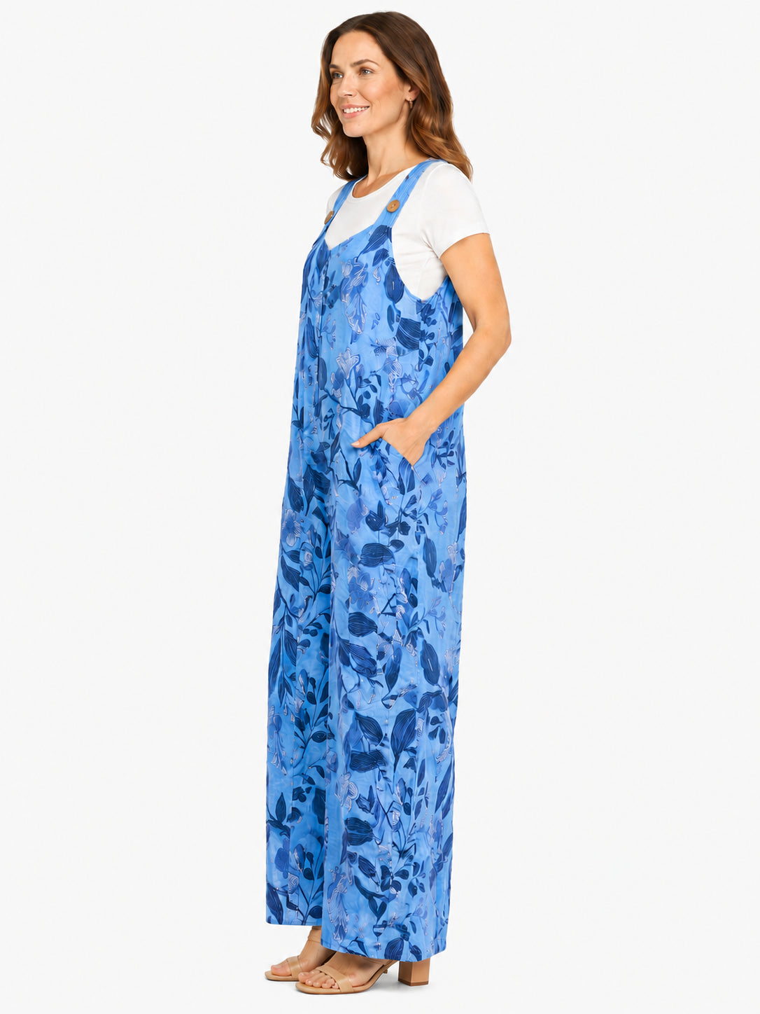 Blue floral wide-leg jumpsuit with adjustable straps over a white short-sleeve top and sandals