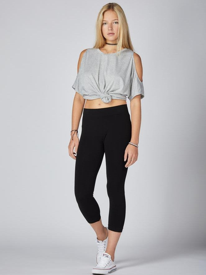 Black 3/4 Seamless Bamboo Leggings by Coast To Coast Trading modeled with casual grey top and white sneakers.