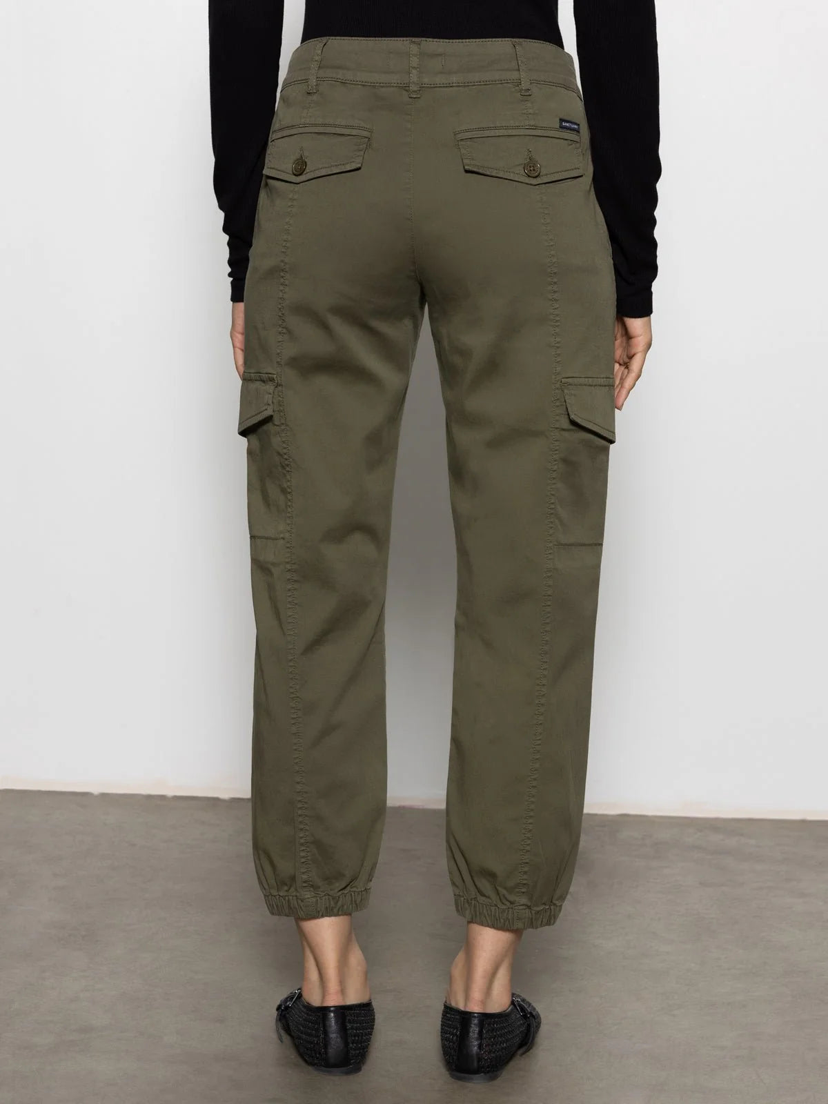 Olive green cargo-style pants with buttoned back pockets and elasticated ankle cuffs.