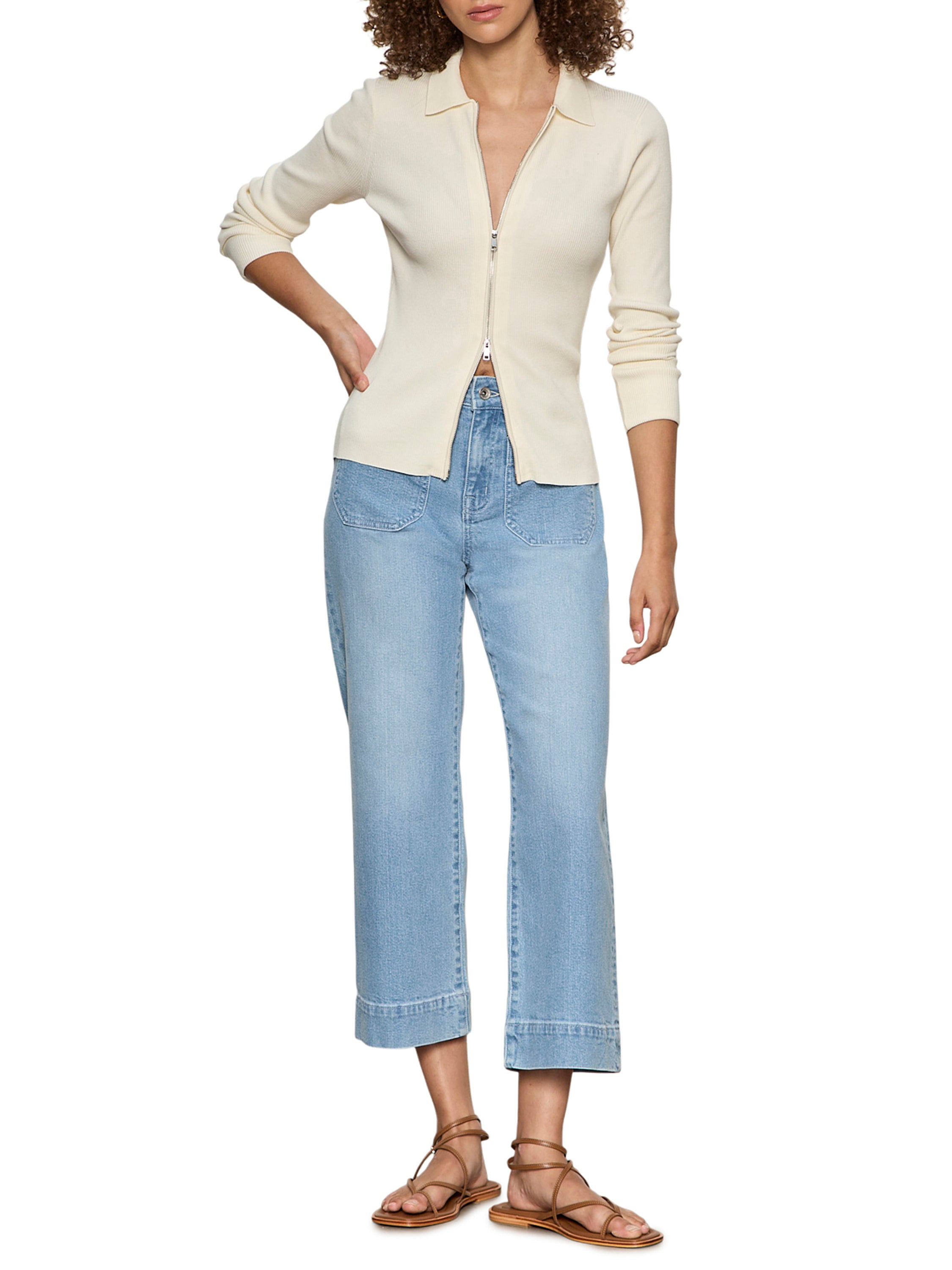 Sanctuary Marine Double Pocket 27” Denim Pant in light wash denim paired with cream zip-up top and sandals.