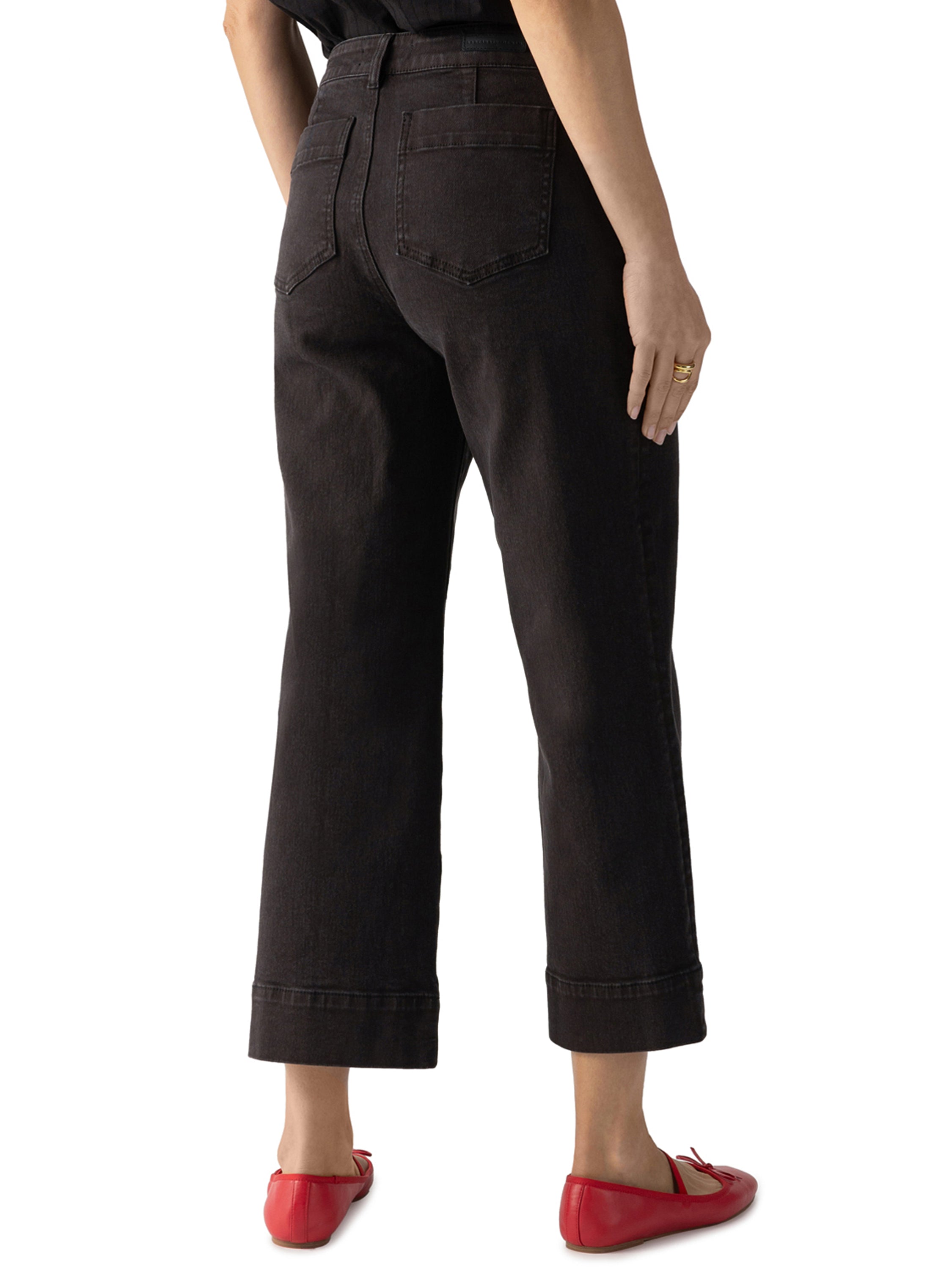 Back view of Sanctuary Marine Double Pocket Denim Pant in dark wash with red flats, styled casually by Sanctuary.