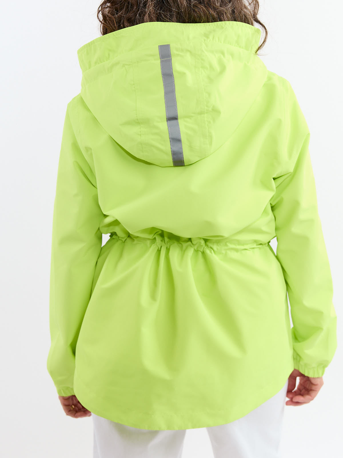 Back view of a bright green hooded rain jacket with a reflective stripe on the hood and cinched waist detail