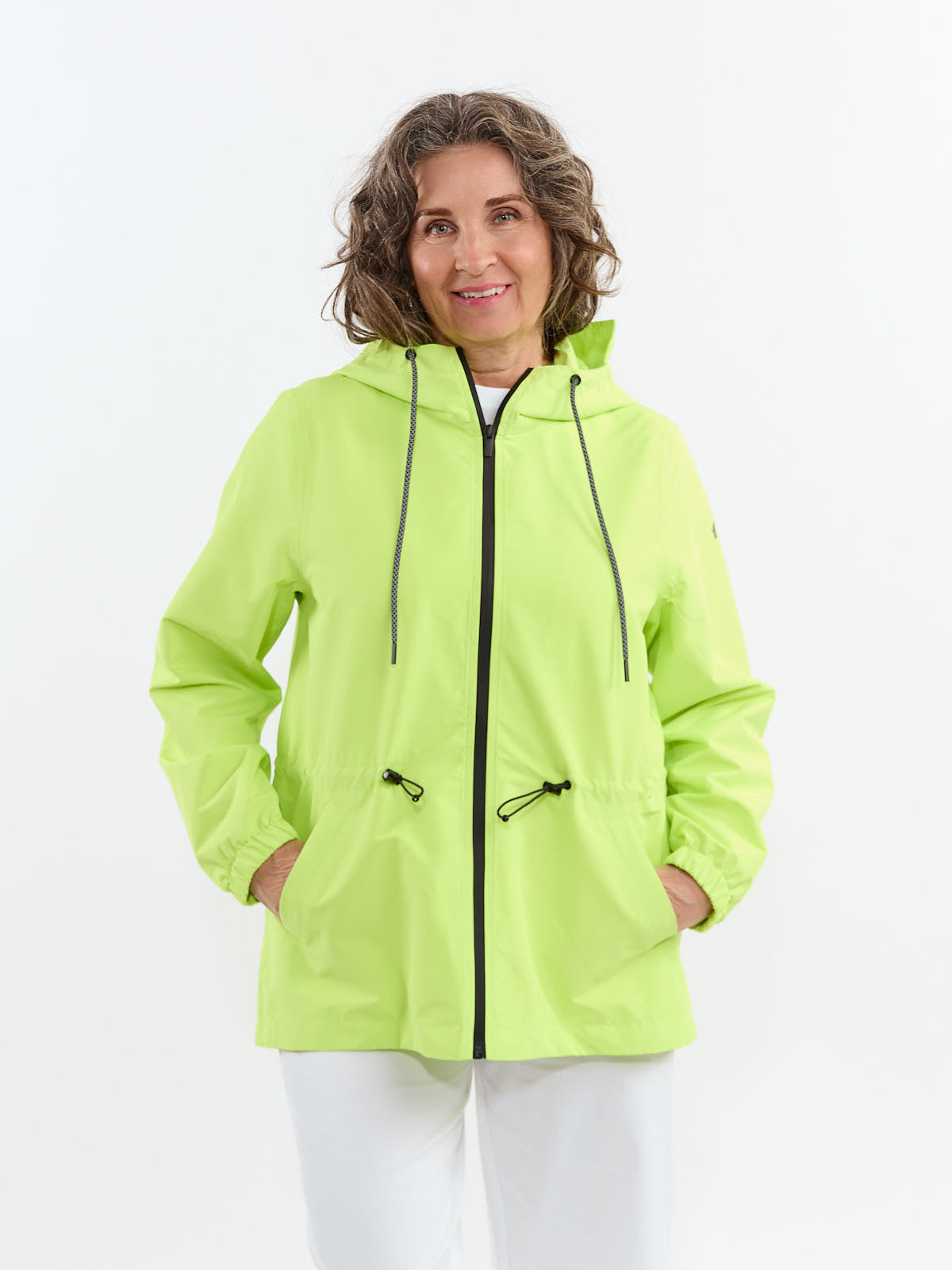 Light green hooded jacket with black zipper and drawstrings worn over white clothing on a person against white background