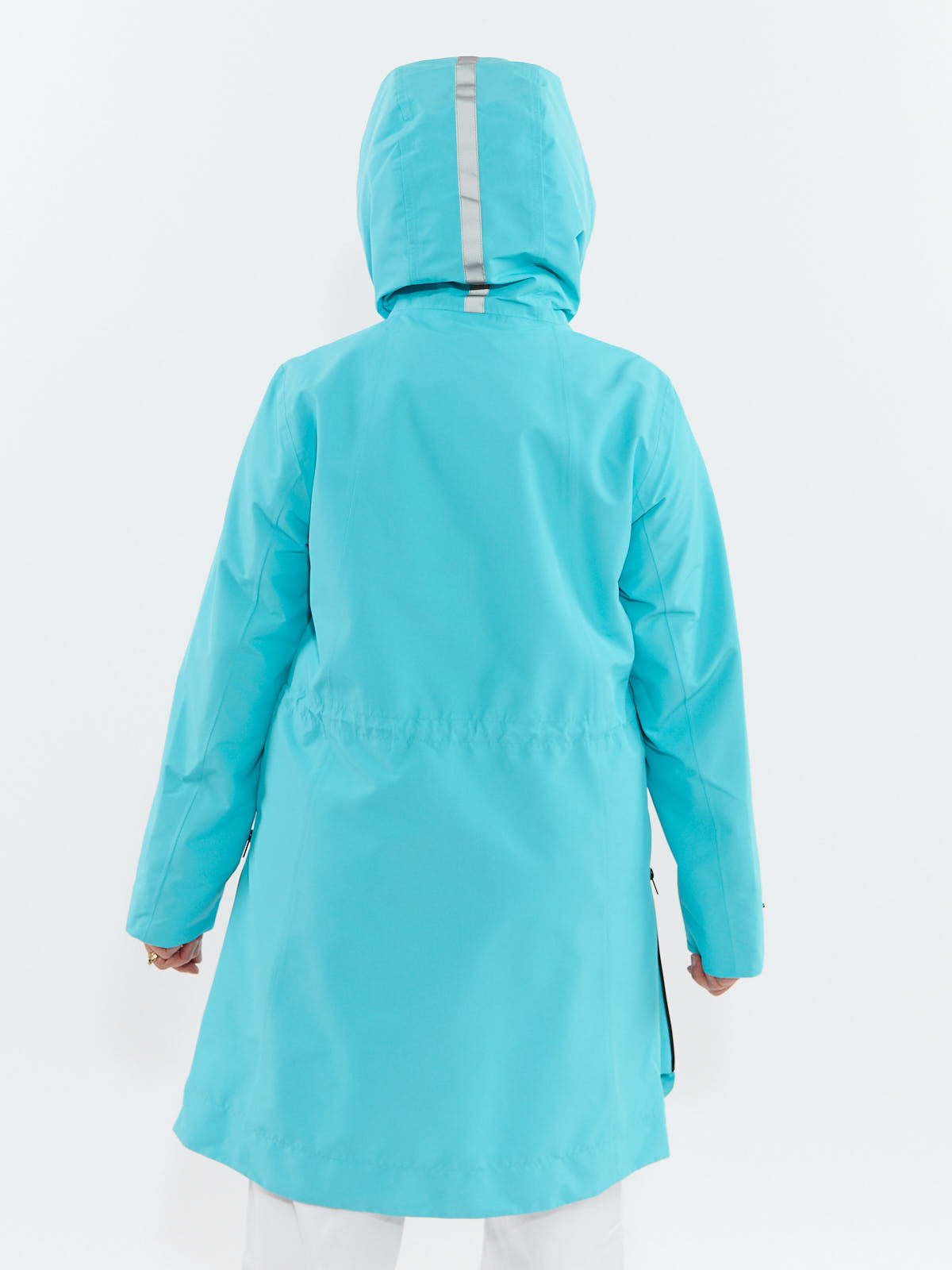 Aqua-colored hooded coat with a reflective stripe down the center back worn over white pants.