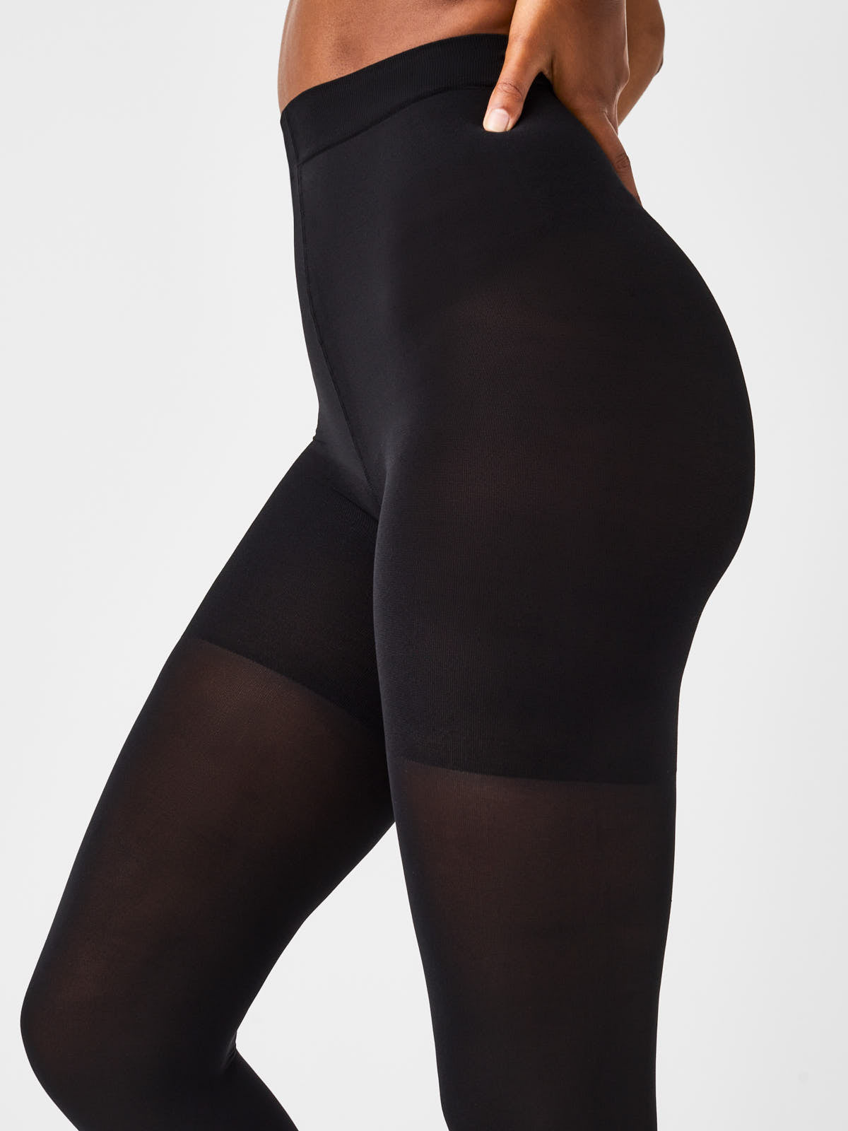 Close-up of black SPANX Luxe Leg Tight-End Control Tights by Spanx highlighting smooth, sleek fit on legs and hips.