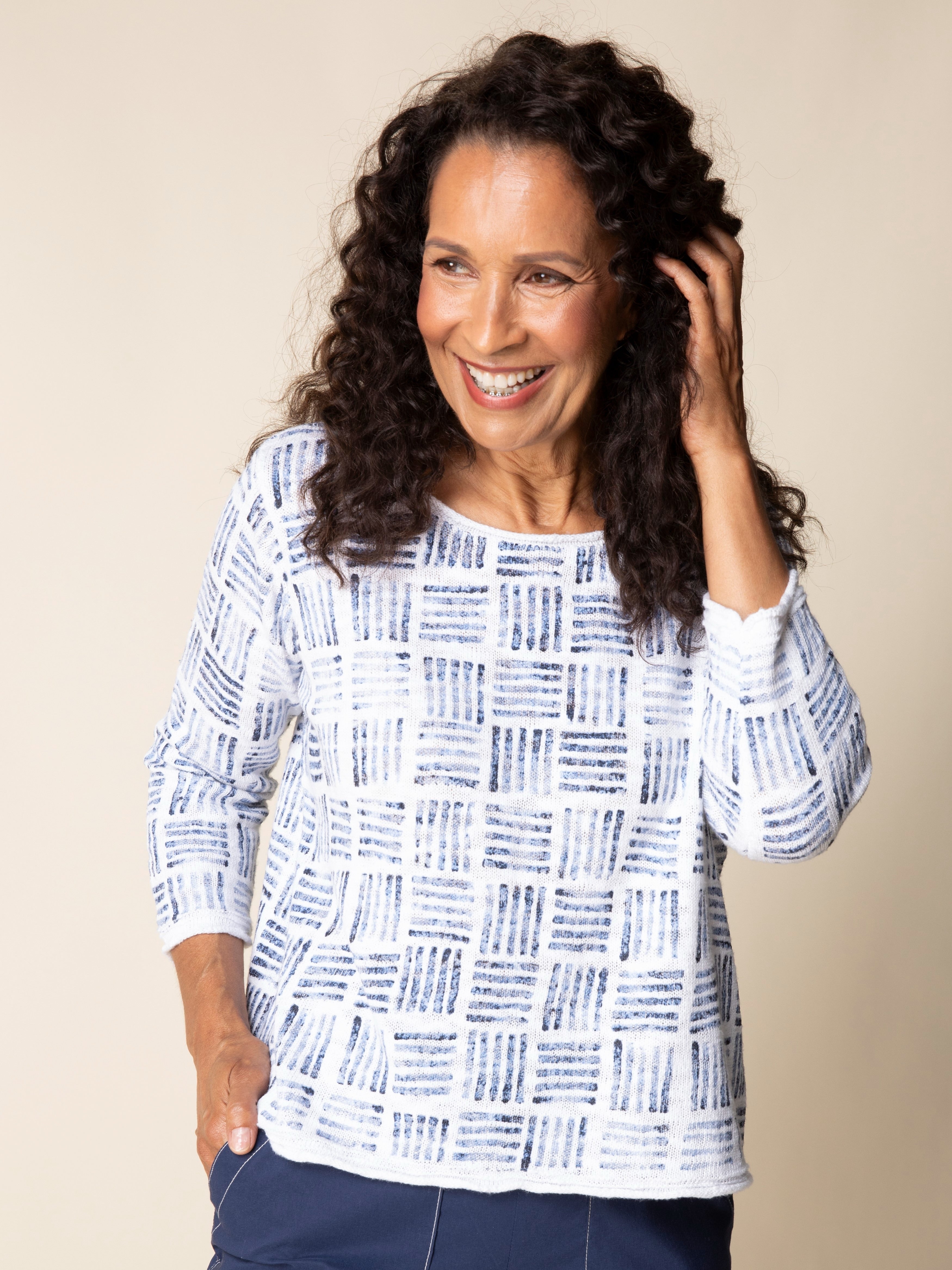 Smiling woman wearing a blue and white Habitat Stamped Drift Cotton Crewneck Sweater by Habitat, styled with navy pants