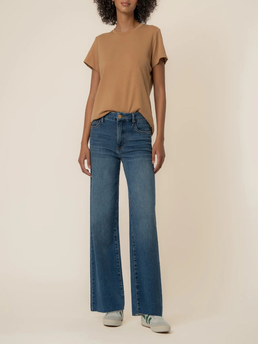 Kut from the Kloth Meg 29” Wide Denim Jeans in medium blue denim paired with a tan short sleeve top and white sneakers