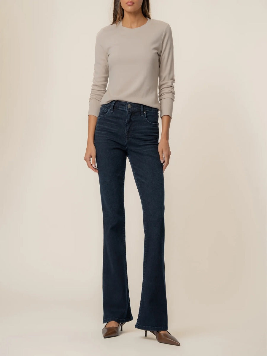 Kut from the Kloth Ana 33” Flare Denim Jeans in dark wash paired with a beige long-sleeve top and brown heels