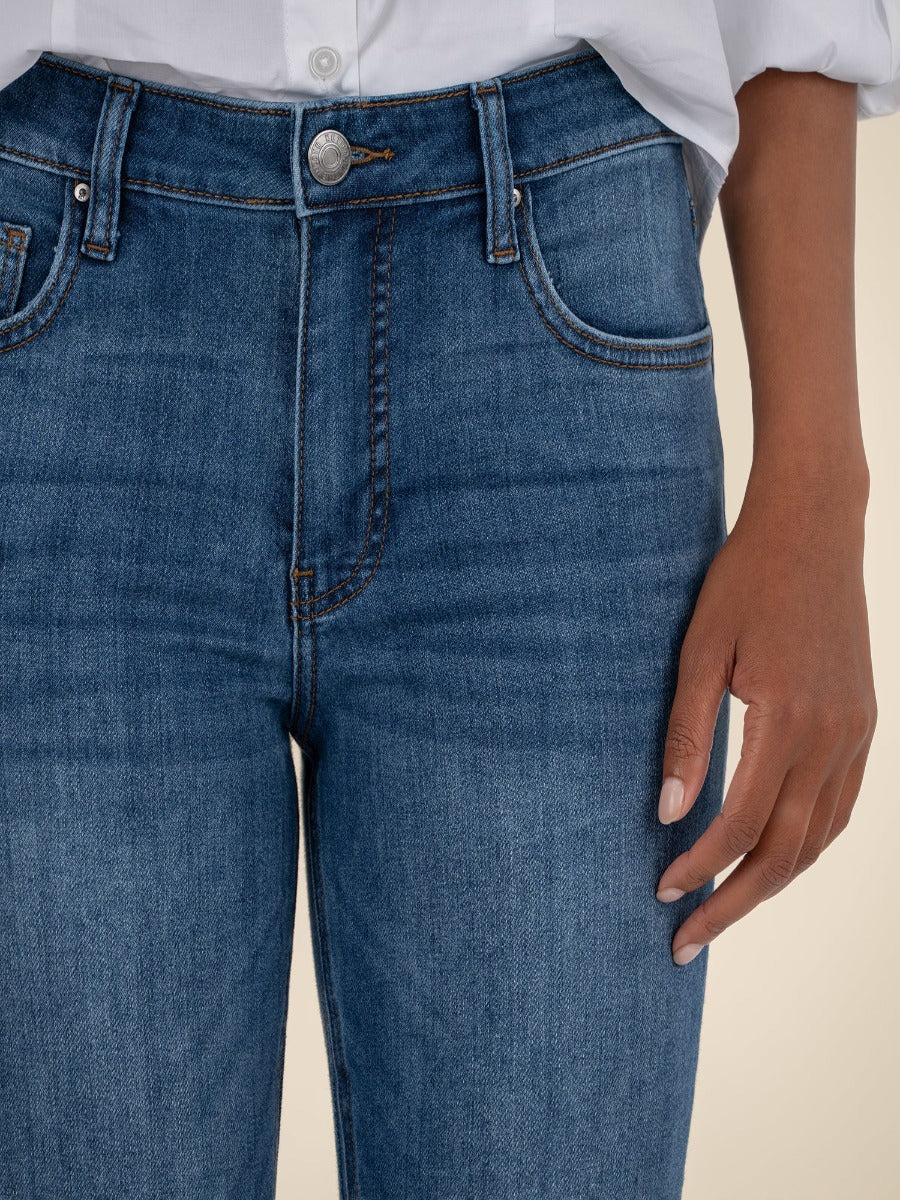 Close-up of blue denim Kut from the Kloth Kelsey High Rise Flare Jeans with front pockets and button detail.