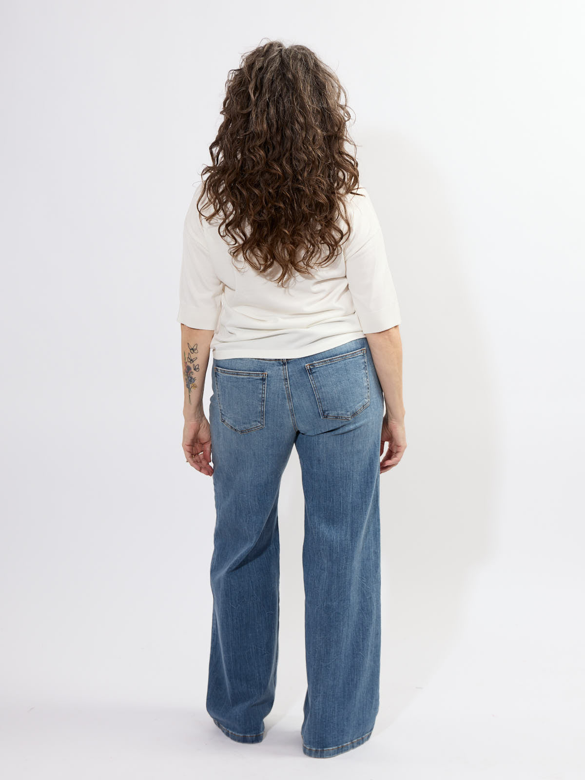 Back view of person wearing Kut from the Kloth High Rise Jean in medium denim with a white top