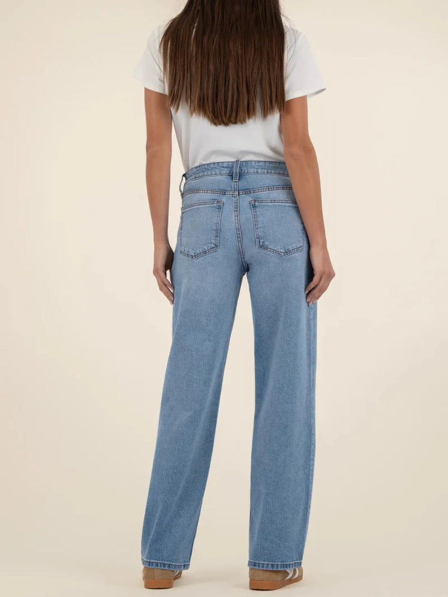 Kut from the Kloth Selena Baggy 31” Straight Leg Jeans in light denim shown from the back with a white top and sandals.