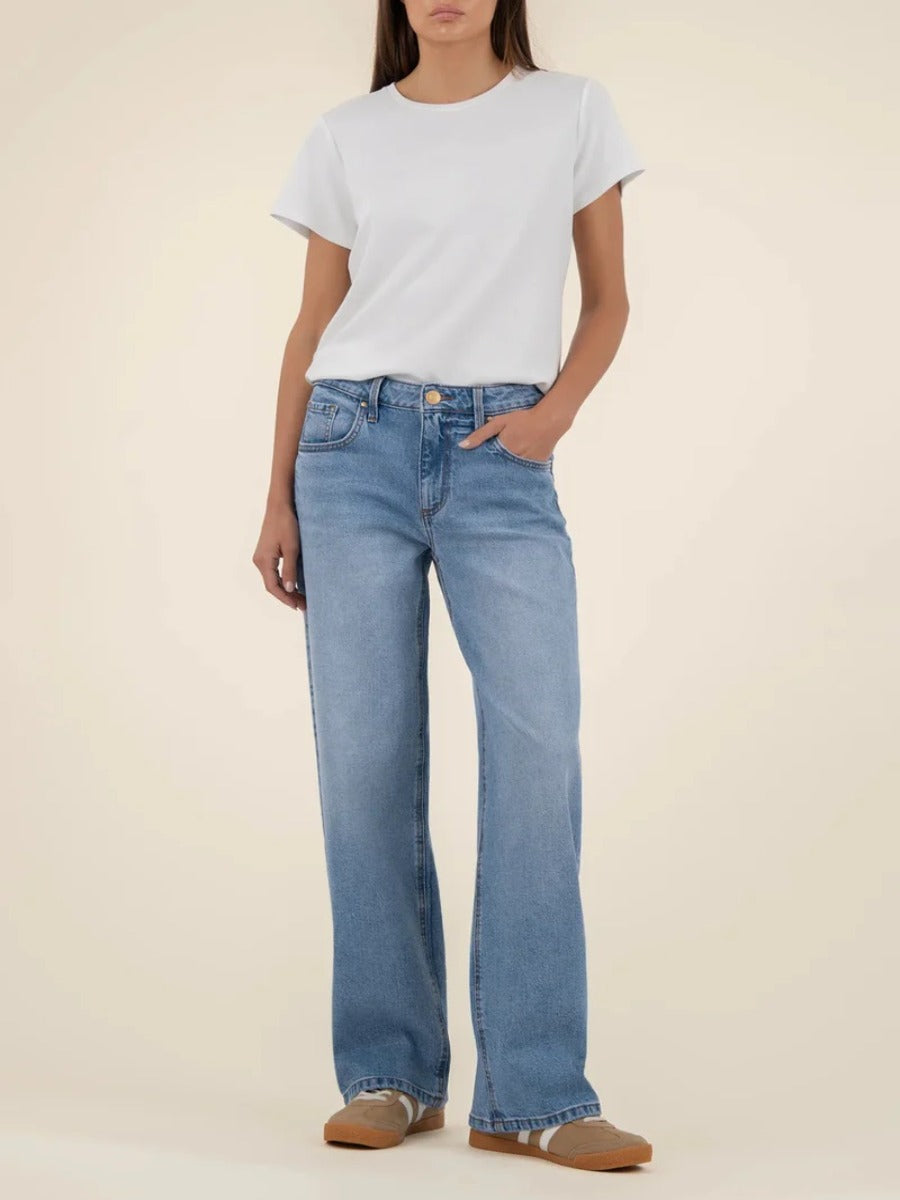 Light wash denim Kut from the Kloth Selena Baggy 31” Straight Leg Jeans styled with a white top and neutral shoes.
