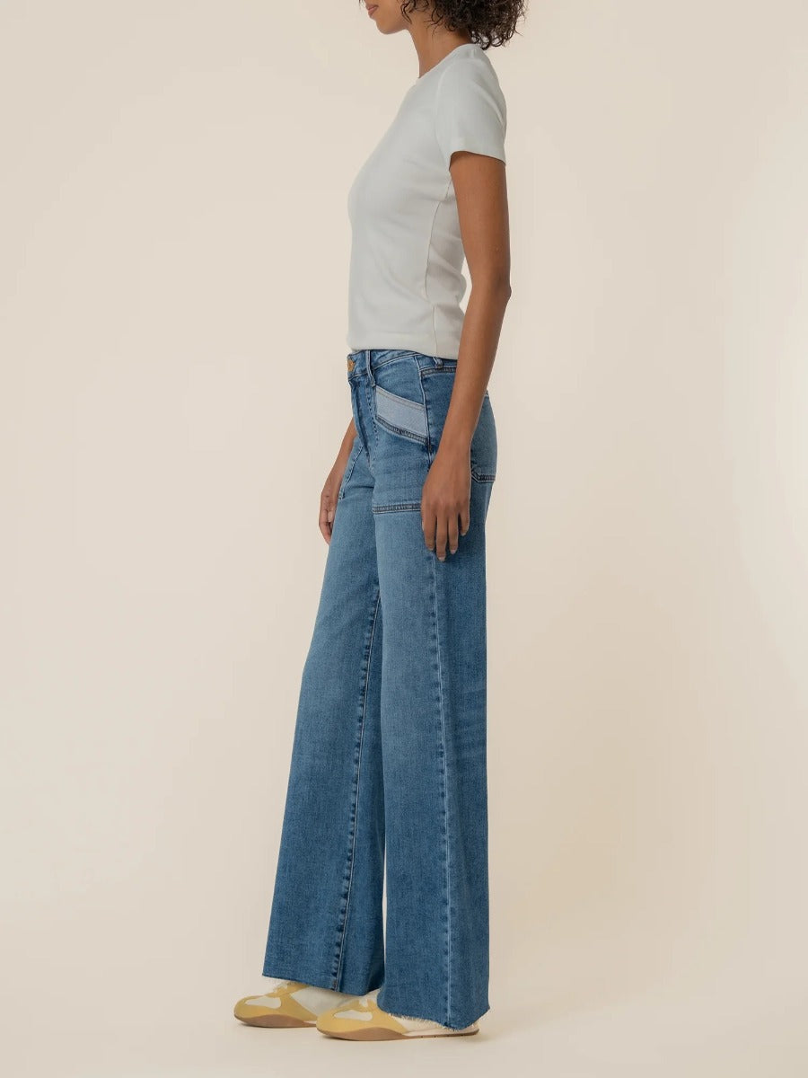 Side view of denim wide leg jeans styled with a white fitted top, Kut from the Kloth Maya High Rise 31” Wide Leg Jeans