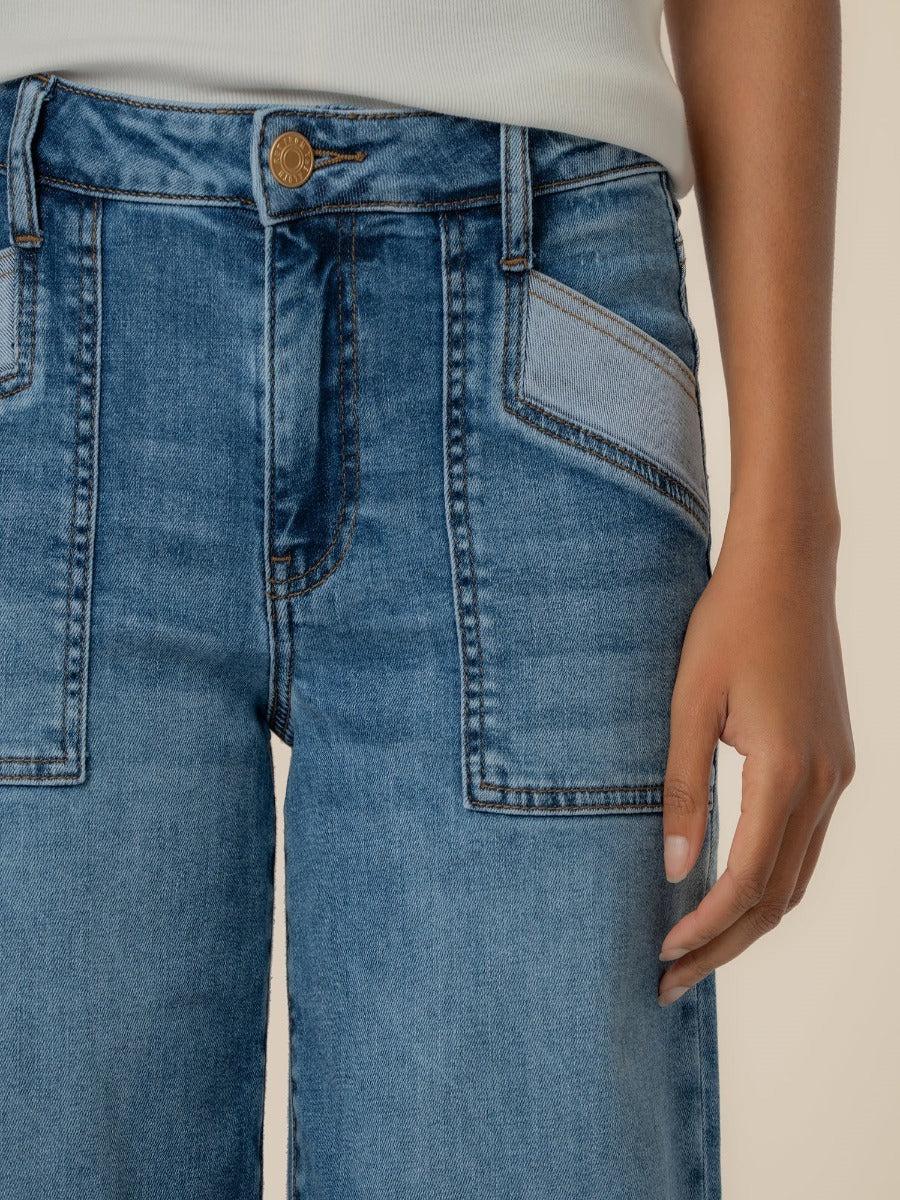 Close-up of blue denim Kut from the Kloth Maya High Rise 31” Wide Leg Jeans with front pockets and brass button closure.