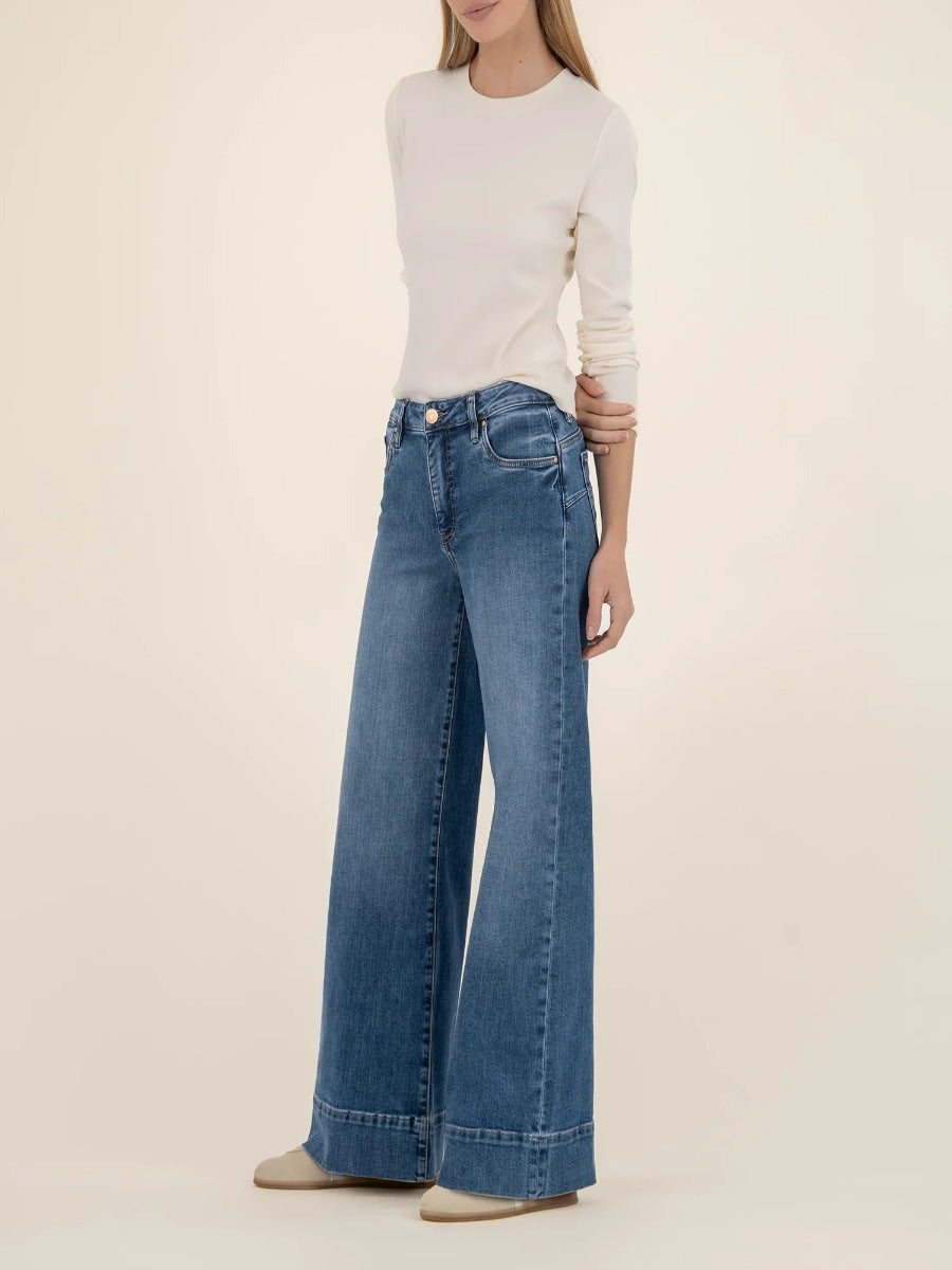 Kut from the Kloth Maya High Rise 31” Wide Leg Trousers in blue denim styled with a cream long sleeve top.