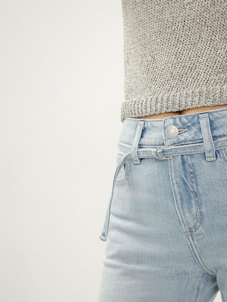 Light blue denim Silver Avery Curvy Trouser with belt detail paired with a textured knit top by Silver.