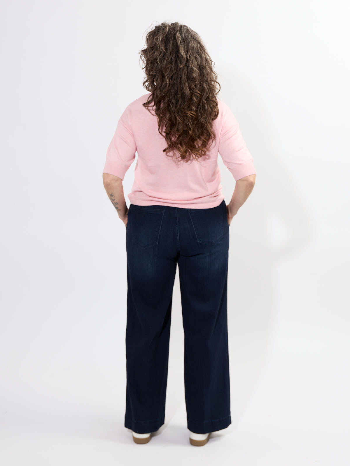 Back view of Liverpool Patch Pocket 31” Trouser in dark denim paired with a light pink top by Liverpool