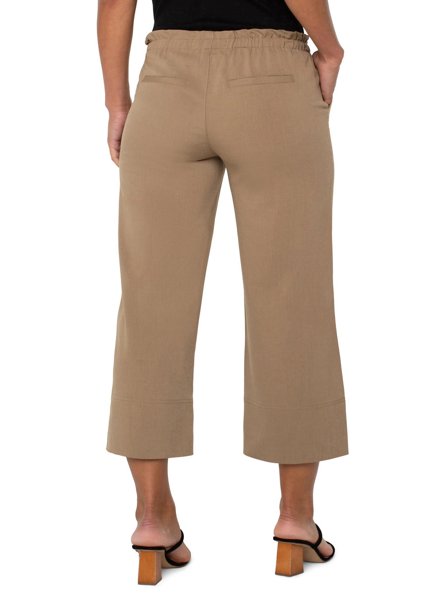 Back view of beige Liverpool Tie Waist Wide Leg 26” Pant on model with elastic waistband and wide cuff detail.