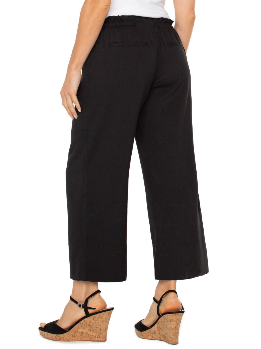 Black Liverpool Tie Waist Wide Leg 26” Pant styled with cork wedge sandals, featuring a relaxed fit and elastic waistband.