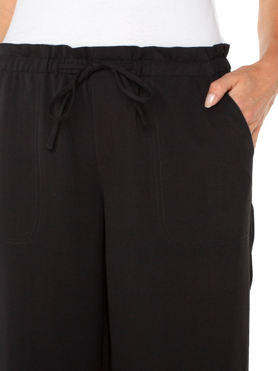 Close-up of black Liverpool Tie Waist Wide Leg 26” Pant featuring elastic waistband and side pocket detail.