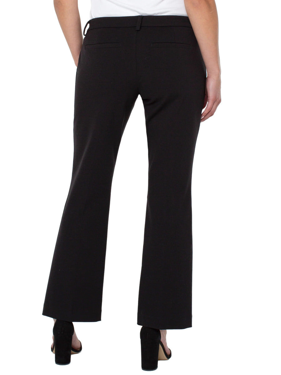 Back view of black tailored trousers paired with black heeled sandals and a white top.