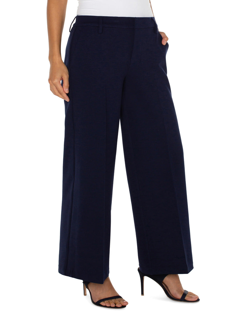 Liverpool Kelsey 31” Wide Leg Trouser in navy blue styled with black heeled sandals and a white top