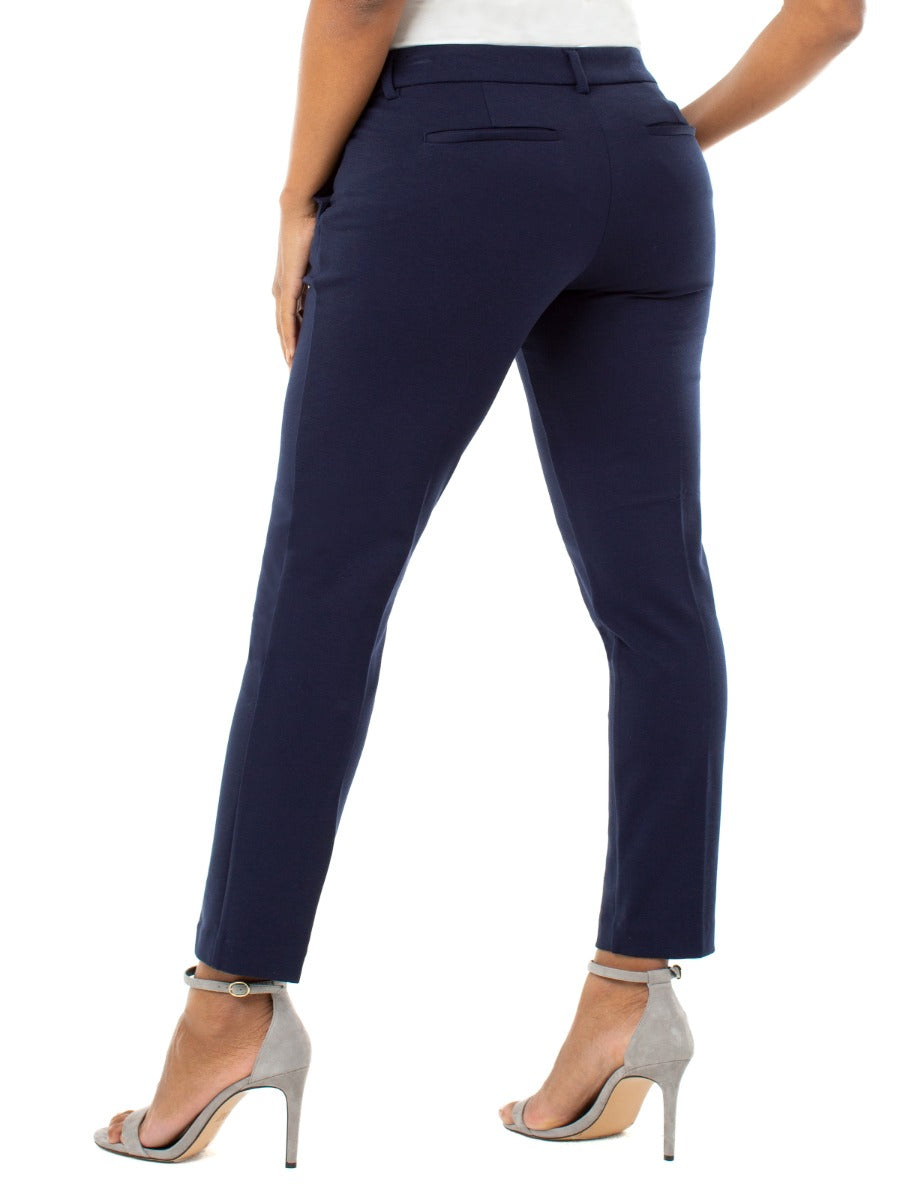 Liverpool Kelsey Solid 29” Pant in navy blue by Liverpool, styled with grey high heel sandals.