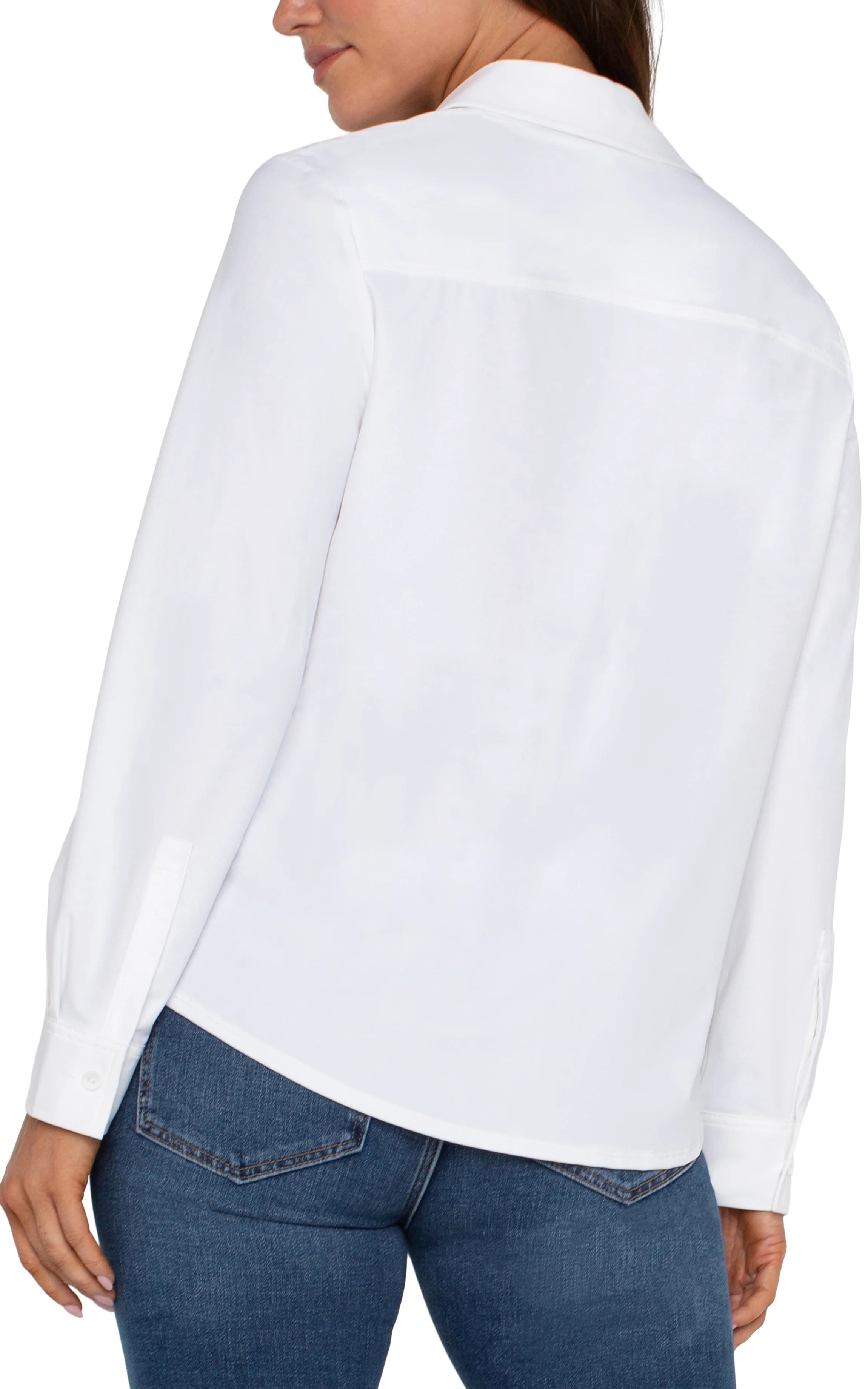 Back view of a white long-sleeve shirt paired with blue denim jeans on a neutral background.