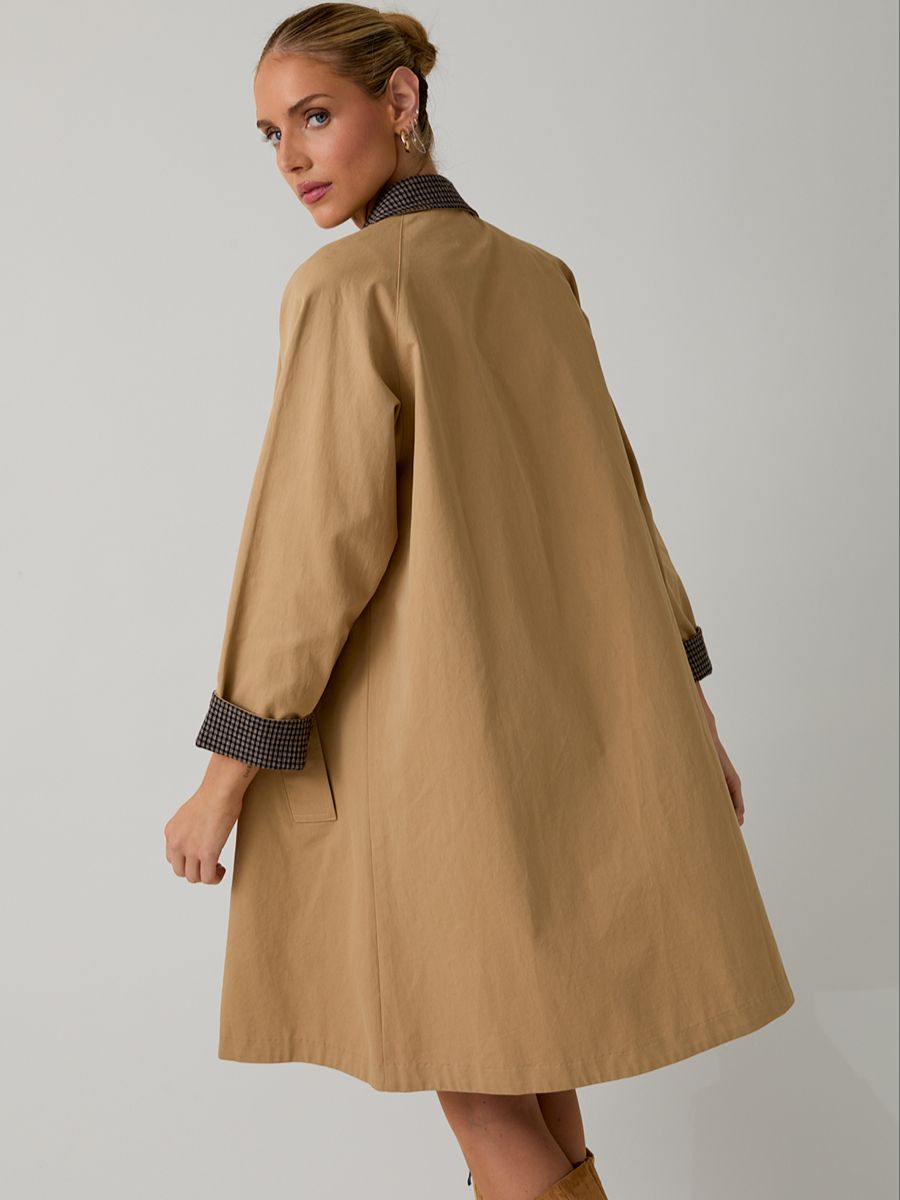 Light brown oversized coat with folded checkered cuffs and collar, viewed from the back against a plain background.