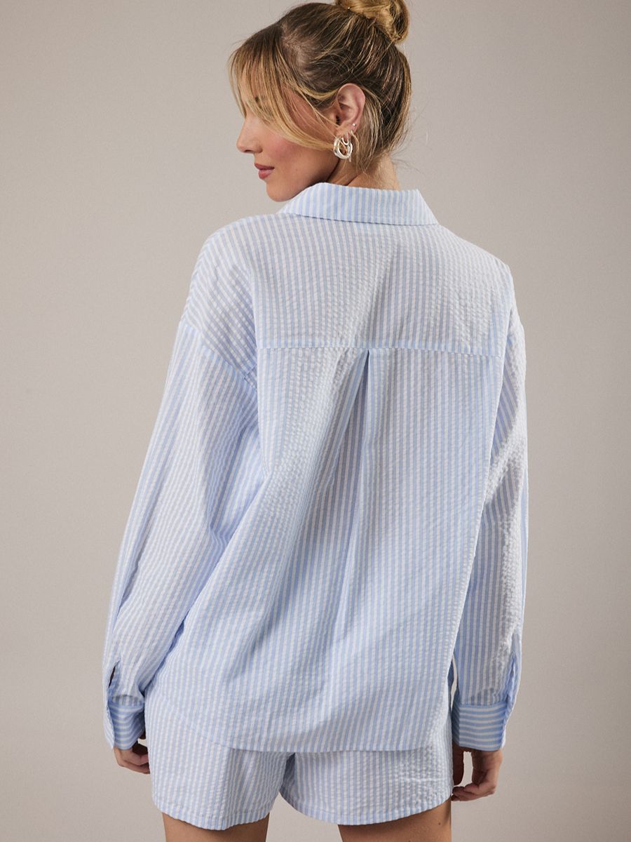 Light blue and white striped long-sleeve shirt with matching shorts shown from the back on light background.