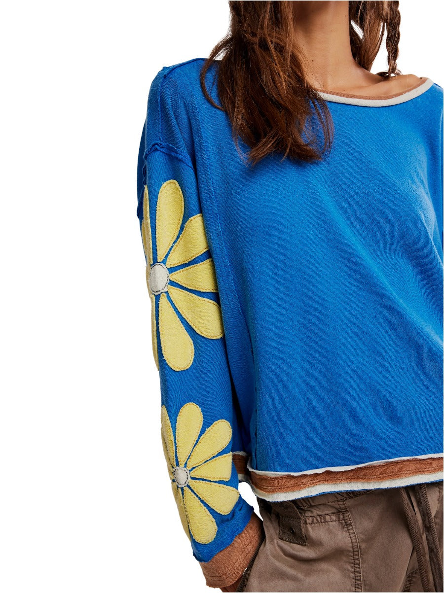 Close-up of Free People You’re A Star Floral Top in blue with yellow floral sleeves and relaxed fit sweater style