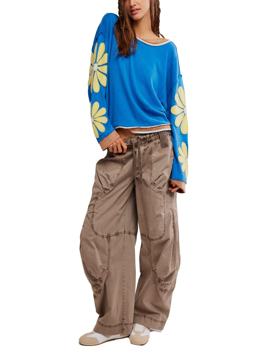 Free People You’re A Star Floral Top in blue with large yellow flowers on sleeves, styled with casual wide-leg pants by Free People.